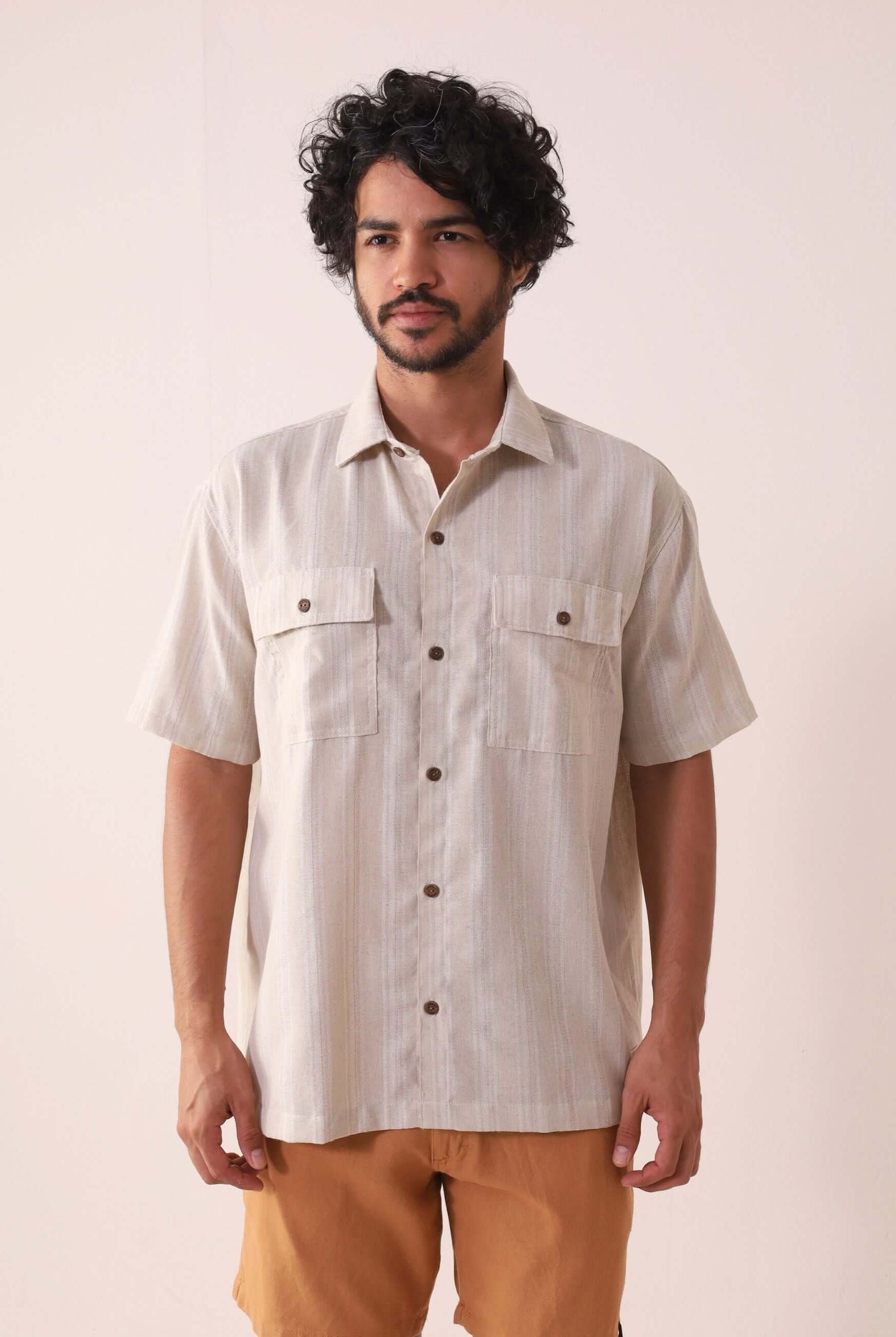 Homem vestindo Camisa Botão Linho Listrado Oversized - Natural da marca Greenish, exibindo estilo casual e sofisticado ao ar livre.