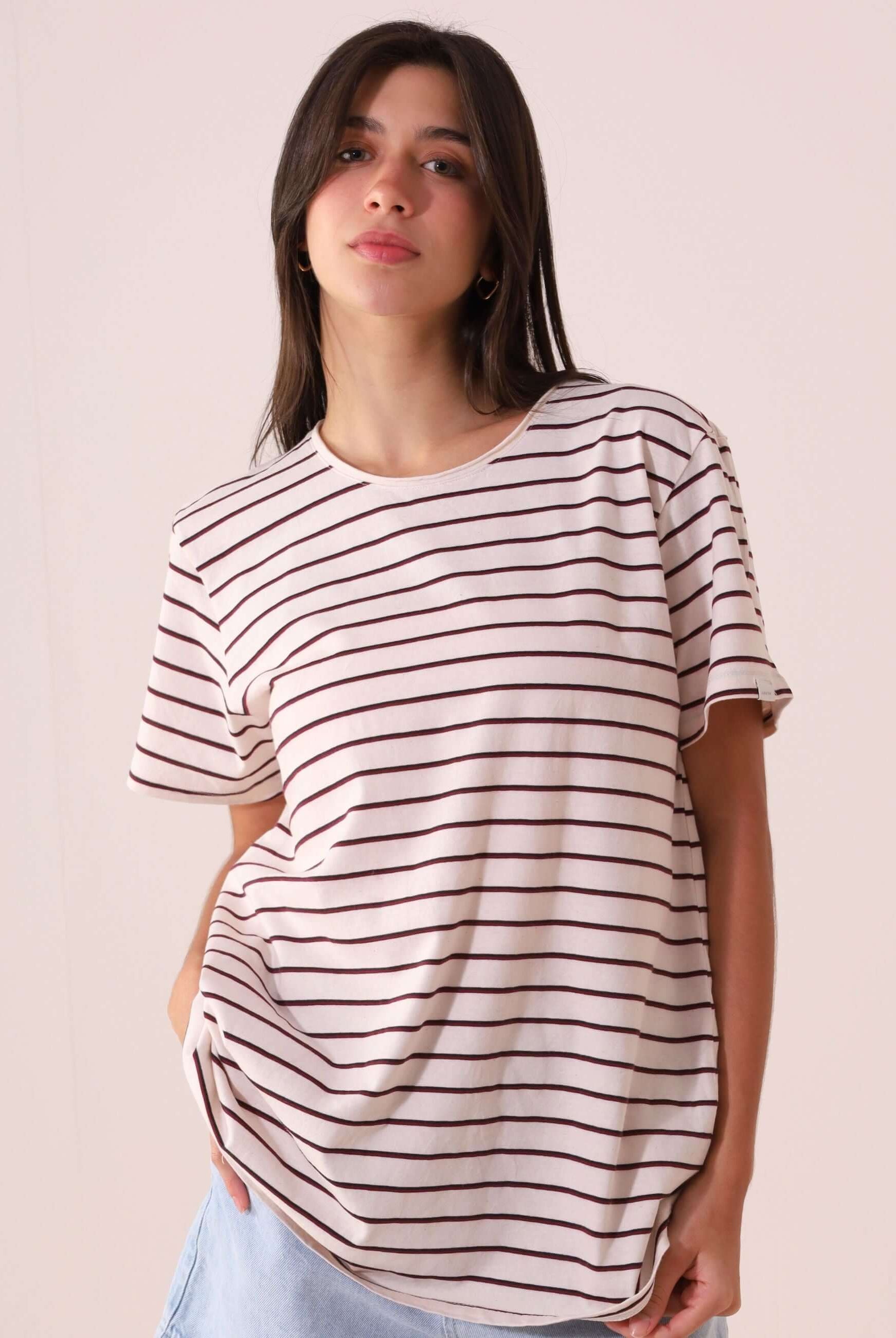 Mulher vestindo CAMISETA NAUTIC - OFF WHITE listrada, confortável e versátil da marca Greenish, em malha de cânhamo e algodão.