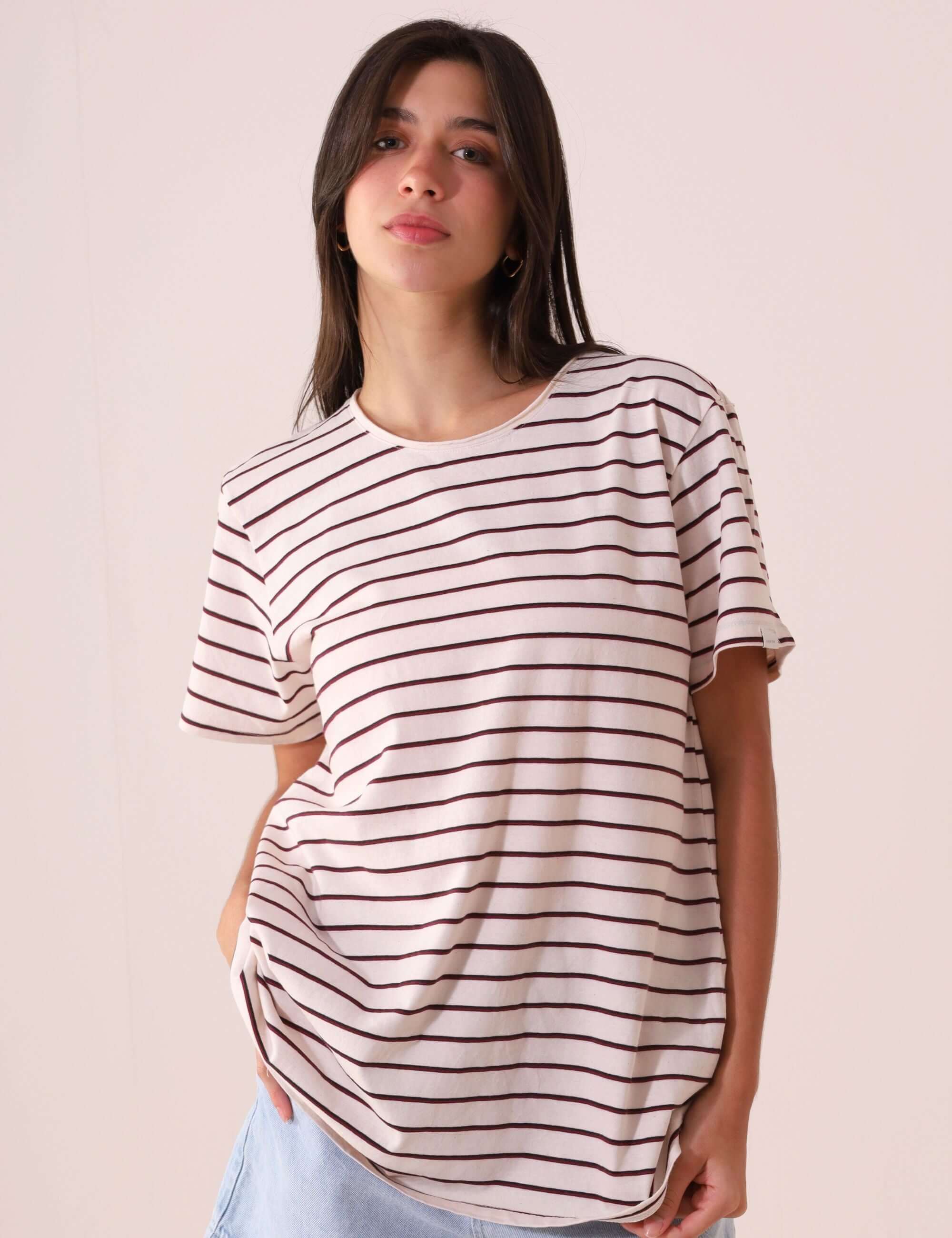 Mulher vestindo CAMISETA NAUTIC - OFF WHITE listrada, confortável e versátil da marca Greenish, em malha de cânhamo e algodão.