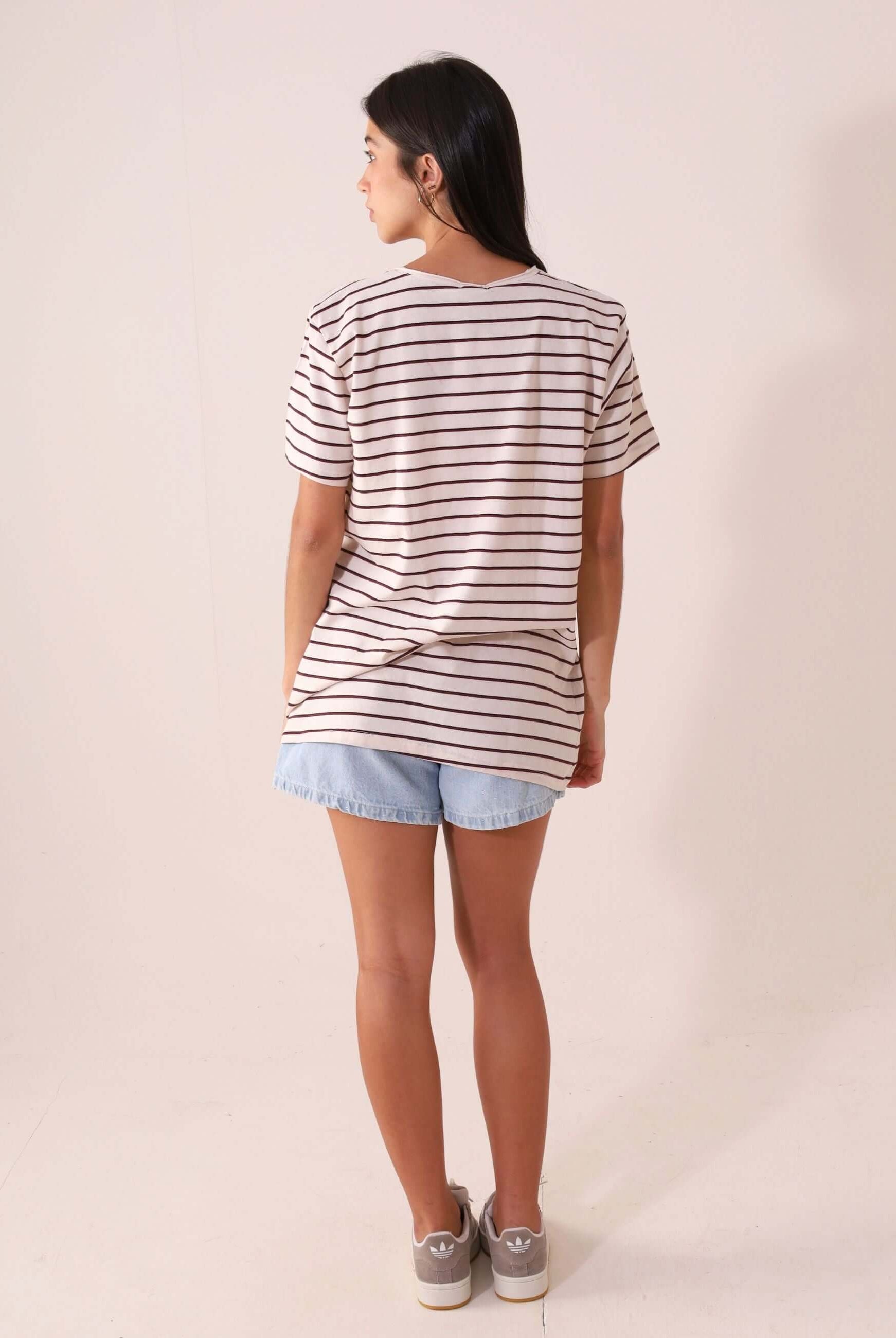 Mulher usando a CAMISETA NAUTIC - OFF WHITE da Greenish, maxi camiseta listrada de cânhamo e algodão, estilo casual e confortável.