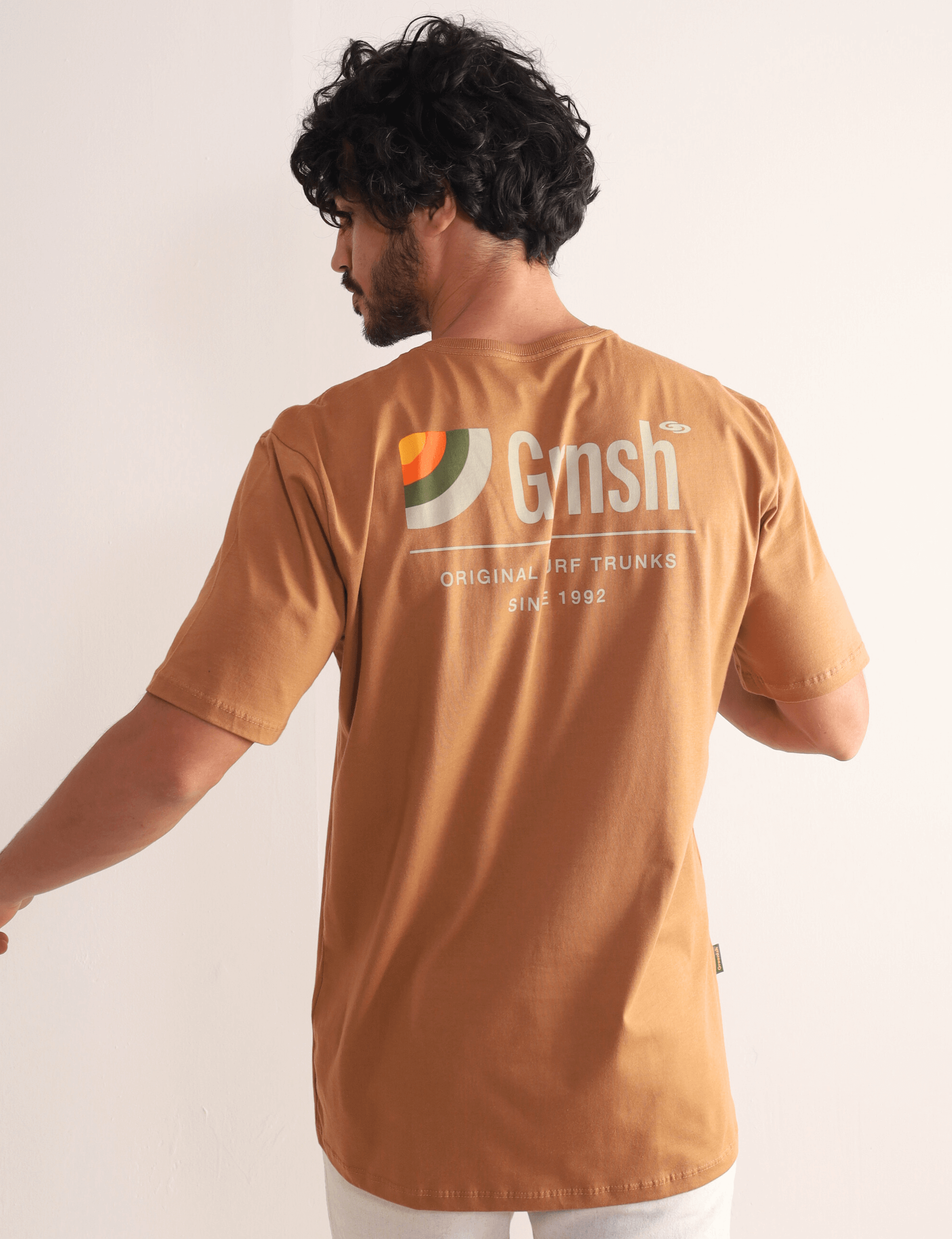 Camiseta Greenish Original Surf Trunks Series I em marron, com estampa litorânea nas costas, estilo versátil e confortável para o dia a dia.