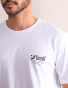 Homem usando camiseta branca Greenish Surf Trunks Series I, estilo litorâneo, confortável, com estampa frontal discreta.