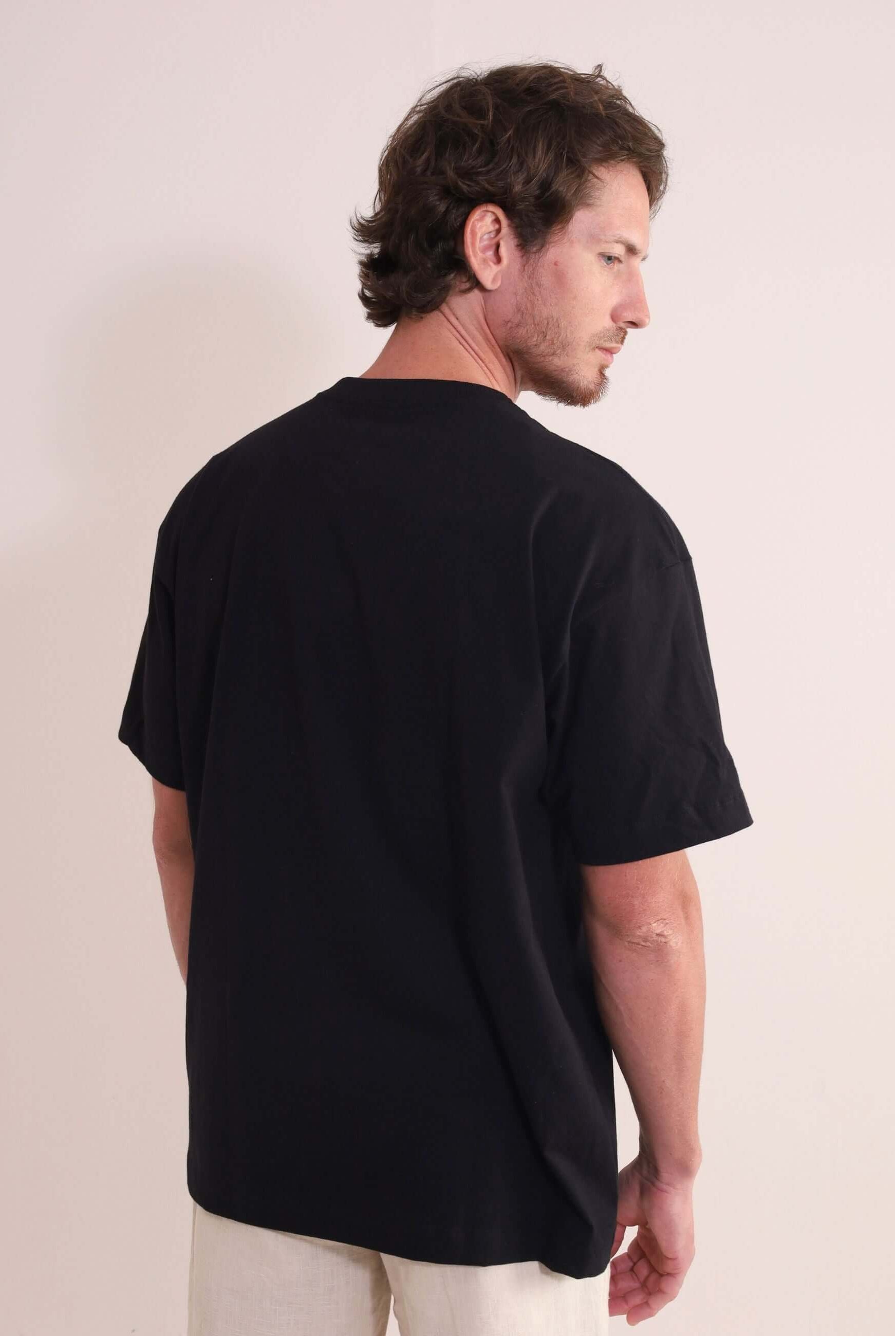 Homem usando Camiseta Oversized Strong - Preto da marca Greenish, destacando a autenticidade e conforto da peça em algodão com gola ribana.