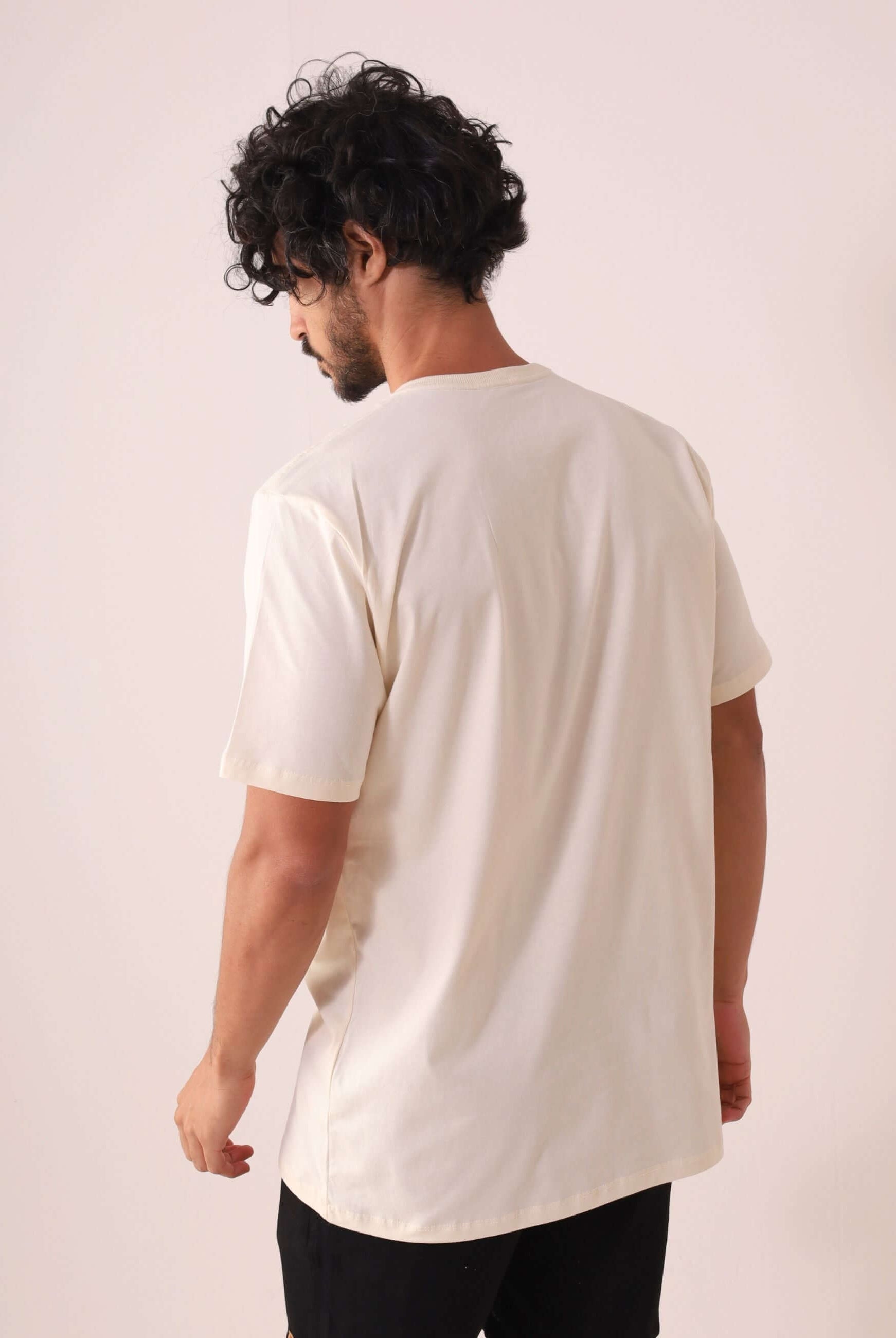 Homem vestindo a Greenish CAMISETA TRADICIONAL BASIC - NATURAL, feita de algodão sustentável, versátil e confortável para o dia a dia.