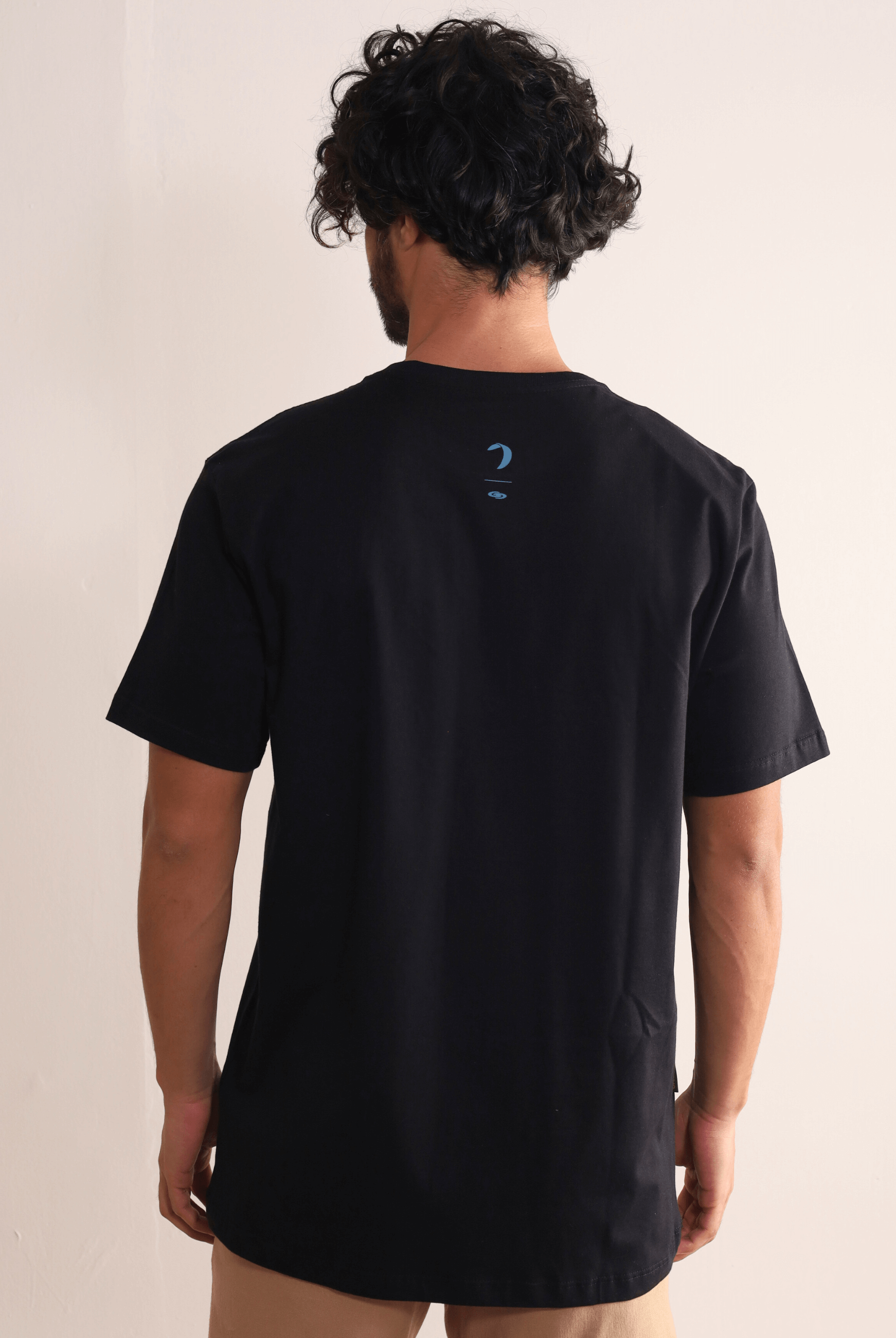 Homem vestindo a Camiseta Wind Is All I Need preta da Greenish, leve e confortável, com estampa nas costas, ideal para movimento.