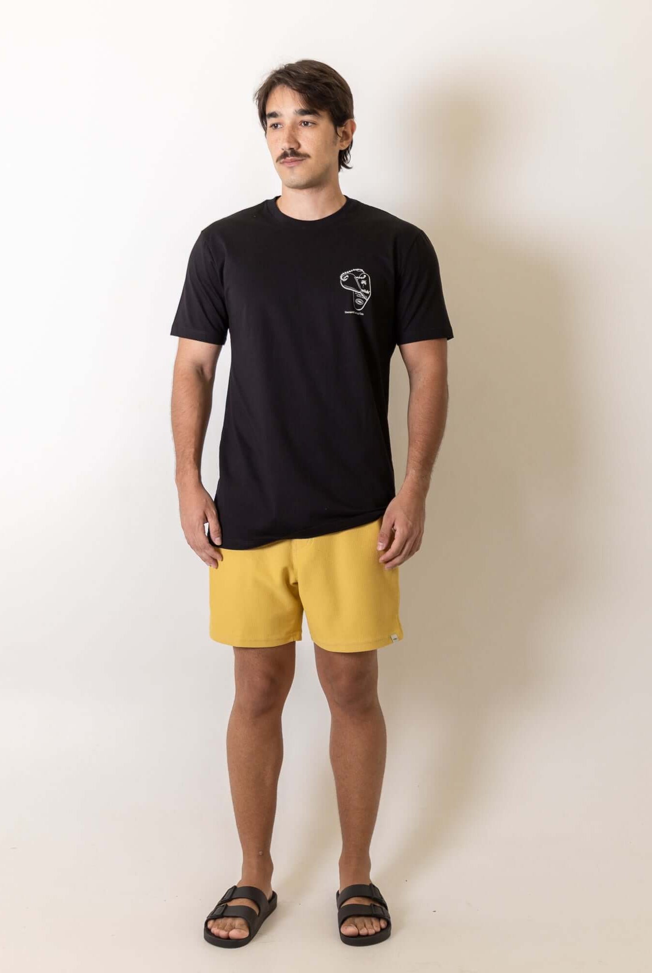 Modelo vestindo Camiseta Fin Key - Preto da marca Greenish com design vintage inspirado no surf e bordado no peito.