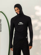 Imagem de modelo usando colete com capuz básico preto da marca Greenish, ideal para esportes aquáticos.