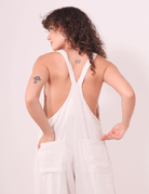 Pessoa usando o Macacão Khay - Natural da Greenish, em Linho Washed Soft, com costas nadador e bolsos traseiros para praticidade e estilo.