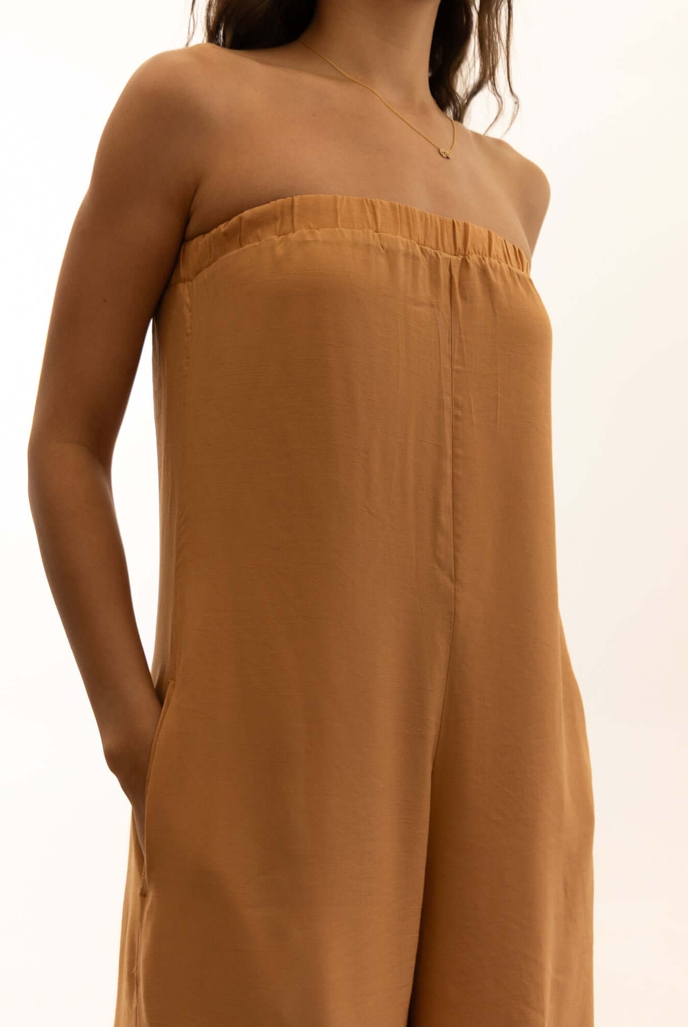 Macacão Leslie - Caqui by Greenish. Elegant strapless jumpsuit in beige color. Perfect for fashion-forward individuals.