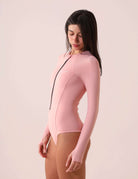 Mulher usando o MAIO SOLID COLOR - ROSA NUDE da Greenish com proteção UV, estilo autêntico e design versátil com zíper frontal.