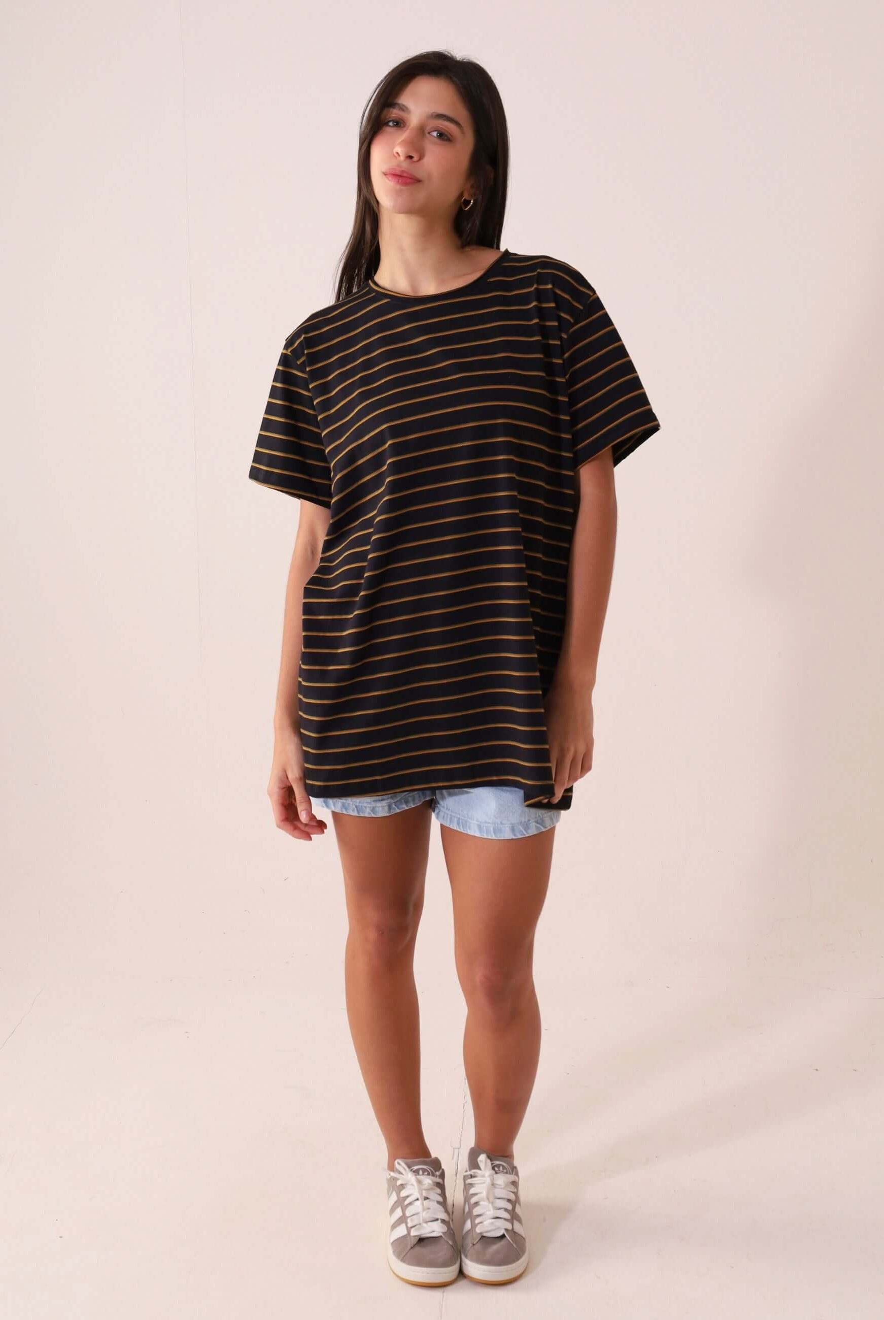 Modelo vestindo CAMISETA NAUTIC - PRETO da Greenish, maxi camiseta listrada de cânhamo e algodão, estilo amplo e confortável, visual clean e natural.