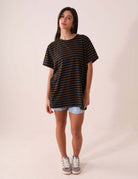 Modelo vestindo CAMISETA NAUTIC - PRETO da Greenish, maxi camiseta listrada de cânhamo e algodão, estilo amplo e confortável, visual clean e natural.