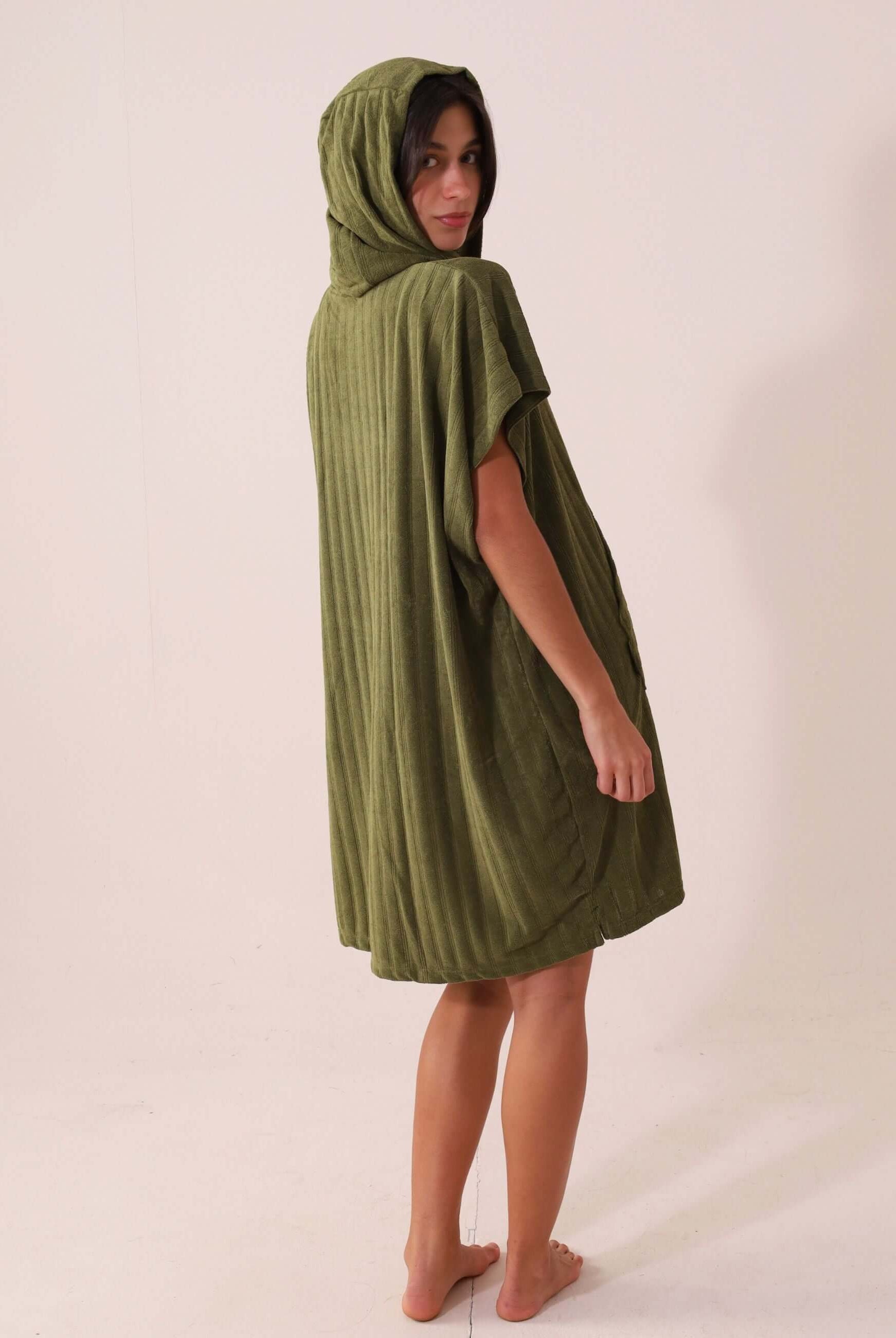 Modelo usando PONCHO CURTO CANELADO - VERDE da Greenish, ideal para praia, com bolsos canguru e tecido atoalhado de rápida secagem.