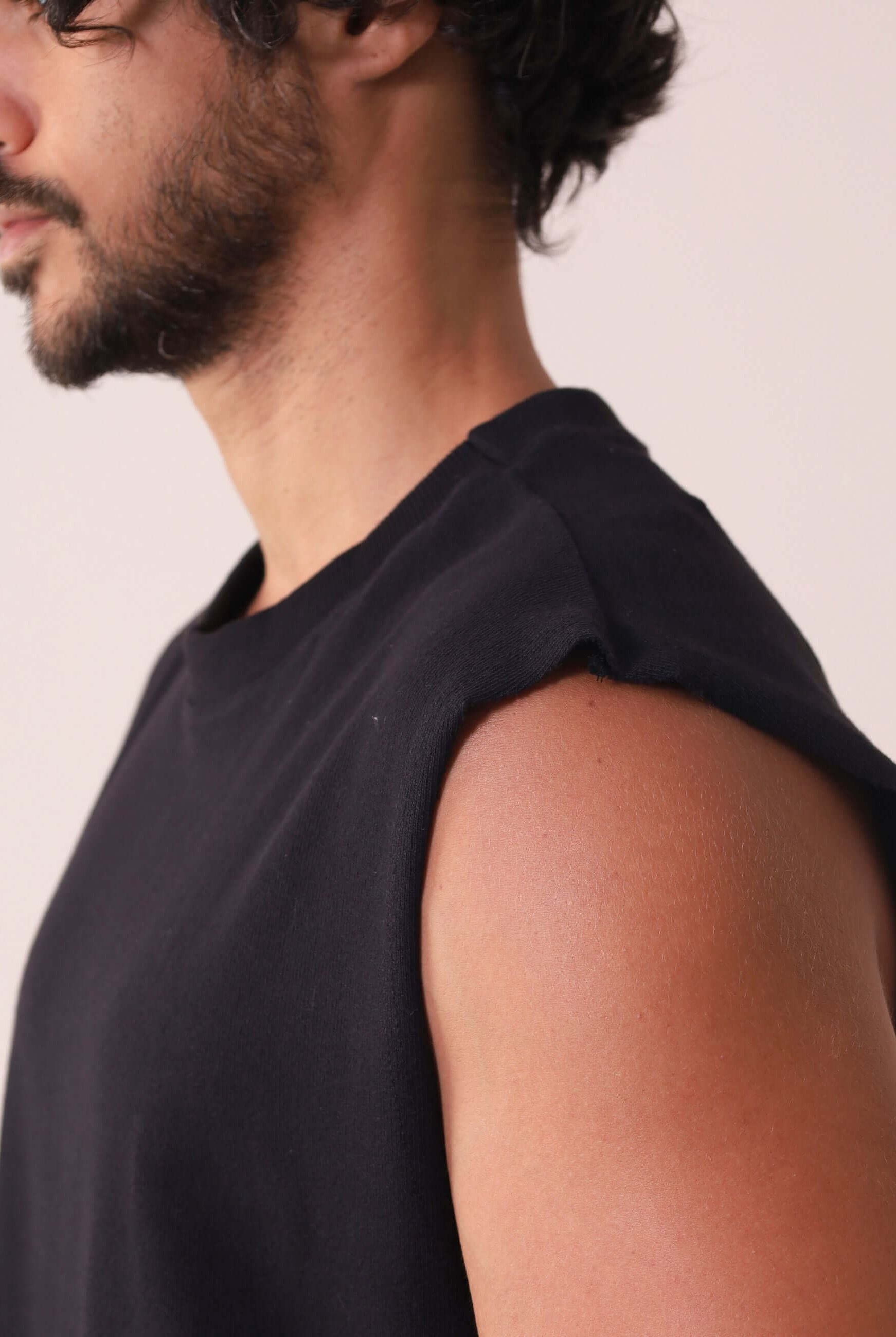 Modelo vestindo a REGATA LARGA WAVES - PRETO da Greenish, em malha 100% algodão, com gola ribana de 6 cm, ideal para dias ao ar livre.