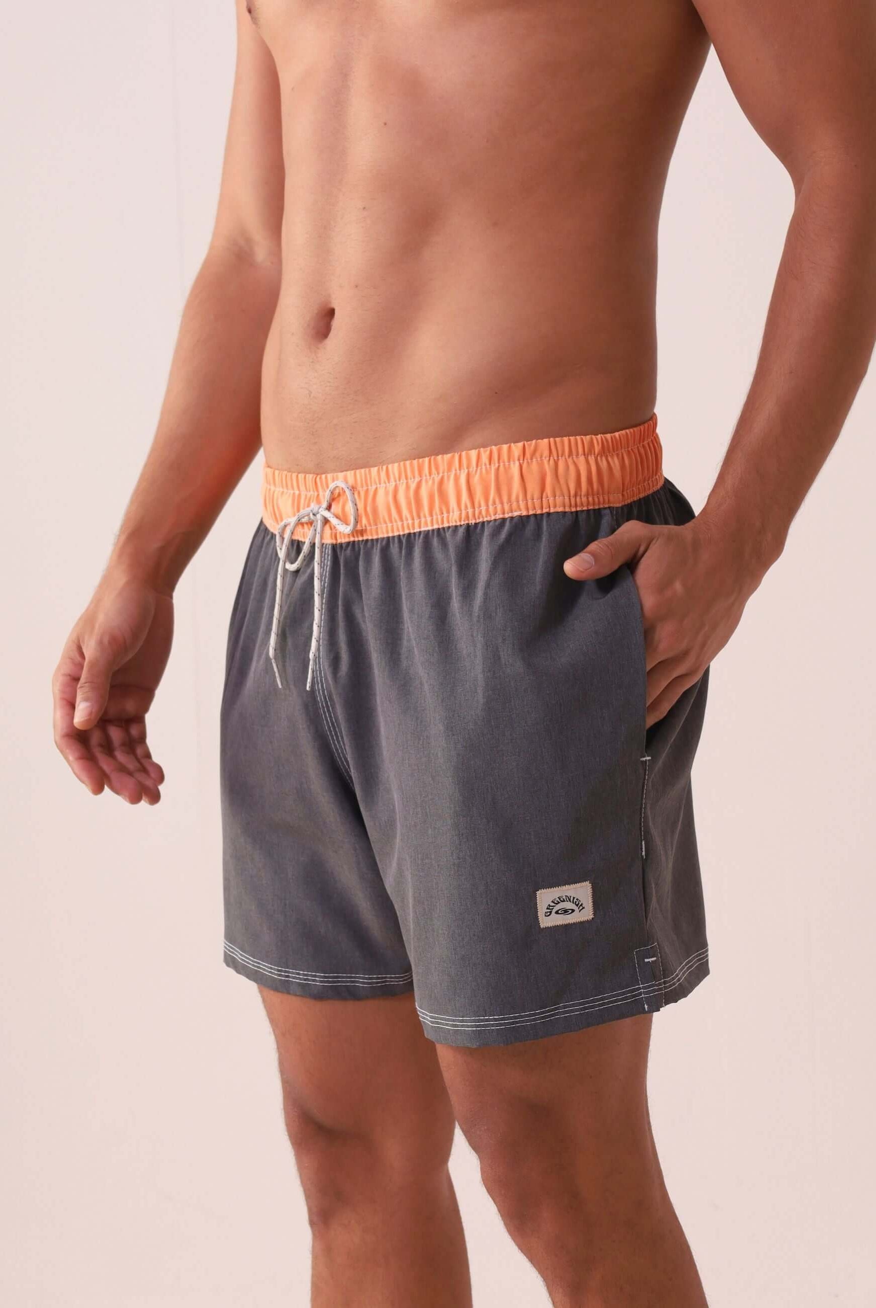 Homem vestindo SHORT VÔLEY BLEND - GRAFITE da Greenish com cós colorido e costura branca contrastante, ideal para conforto e estilo.