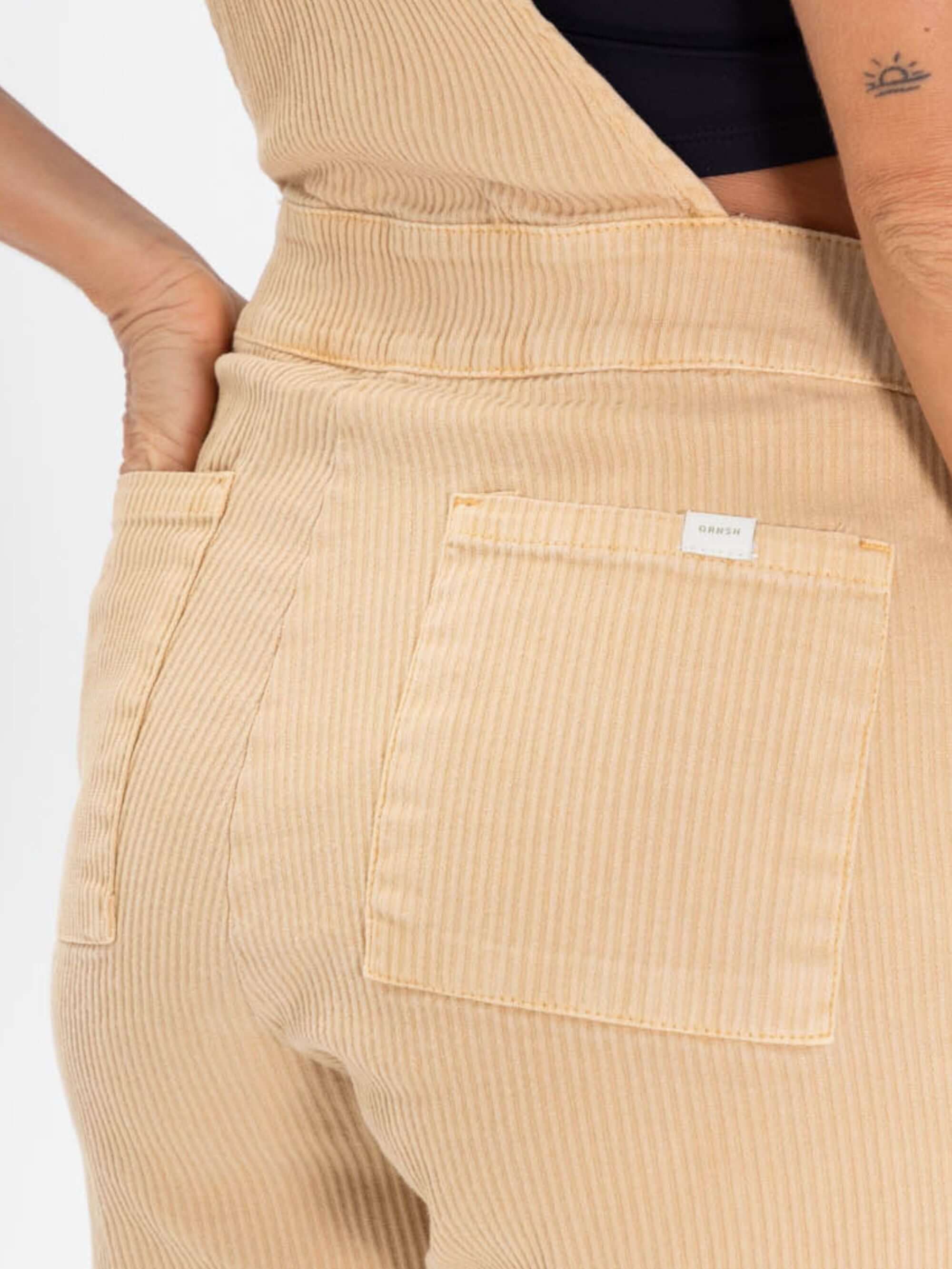 Detalhe do Macacão Jardineira Suy da Greenish, em algodão, com bolsos e caimento soltinho, estilo moderno e confortável.