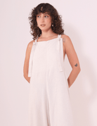 Mulher vestindo Macacão Khay - Natural da marca Greenish, feito de linho lavado macio, com design cavado e costas nadador, ideal para o verão.