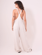 Modelo vestindo Macacão Khay - Natural da marca Greenish em linho, com design moderno e costas nadador, ideal para dias quentes.