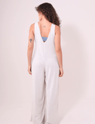 Alt Tag: Mulher vestindo Macacão Lais Natural marca Greenish, com decote V nas costas e pernas amplas, estilo confortável e casual.