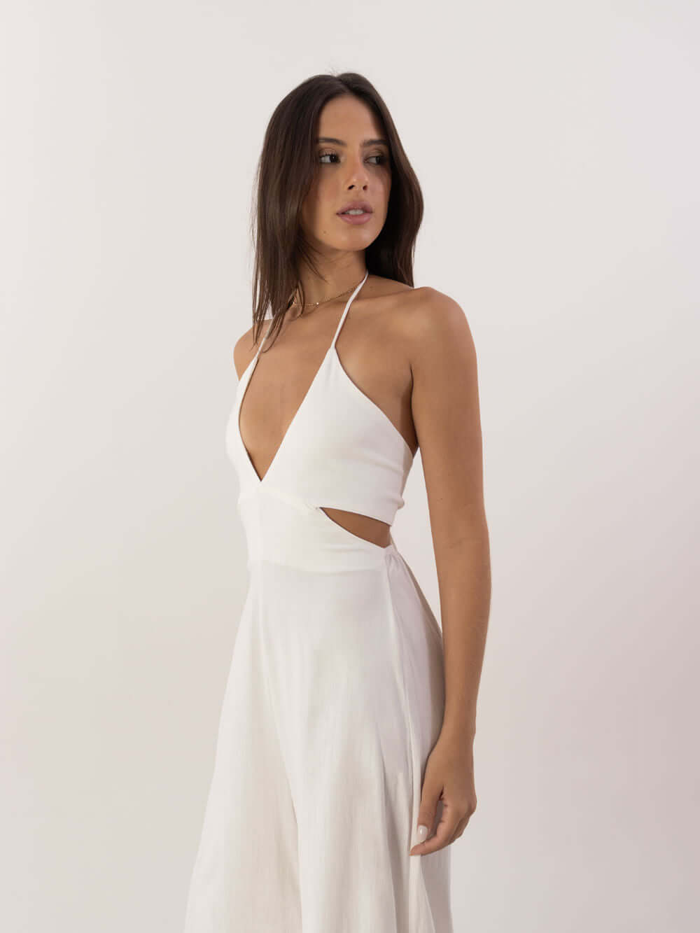 Modelo usando o Macacão Longo Alyssa off white da Greenish, com decote em V e recorte lateral estiloso.