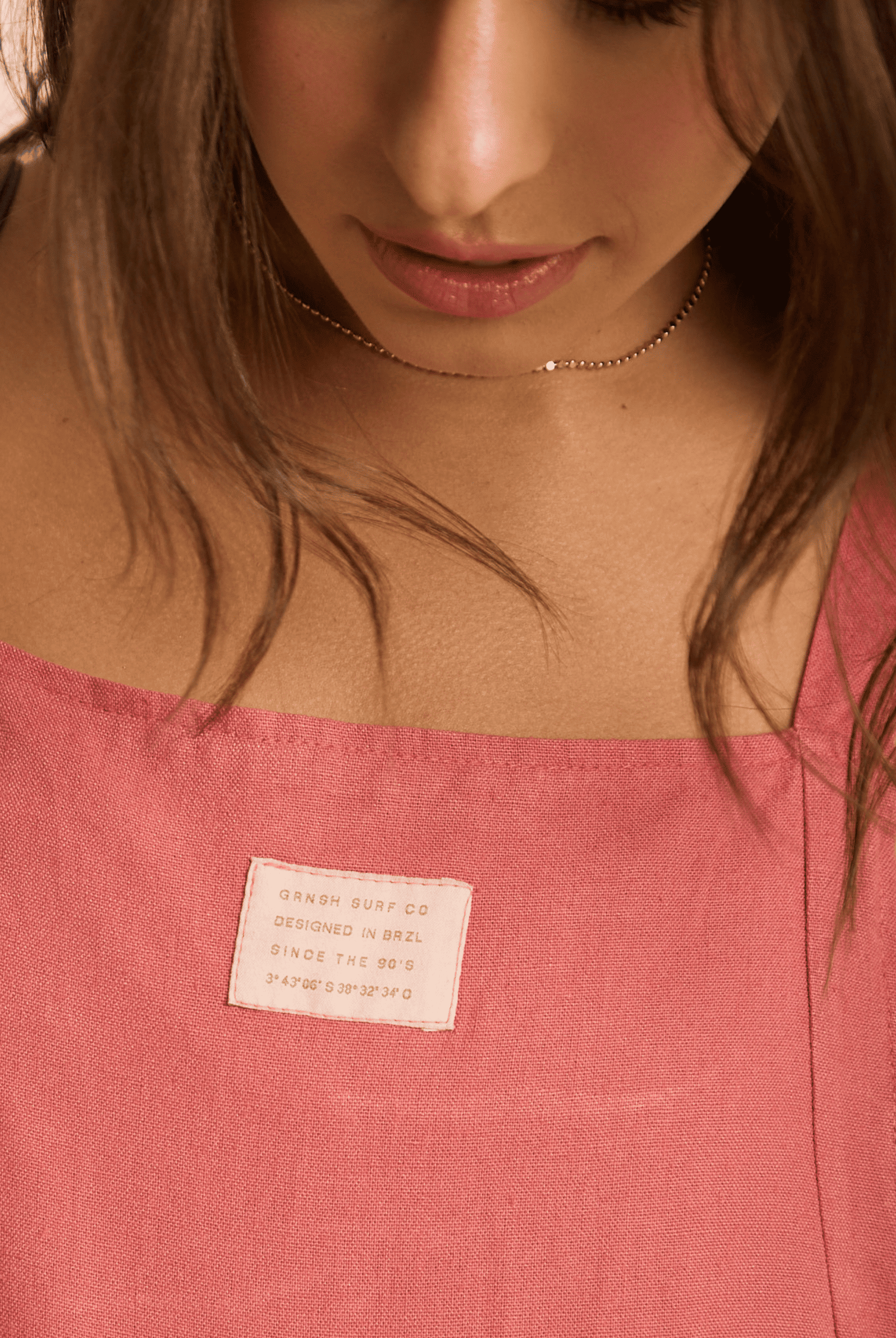 Imagem do macacão telha da Greenish, com detalhe da etiqueta, destacando estilo e conforto.