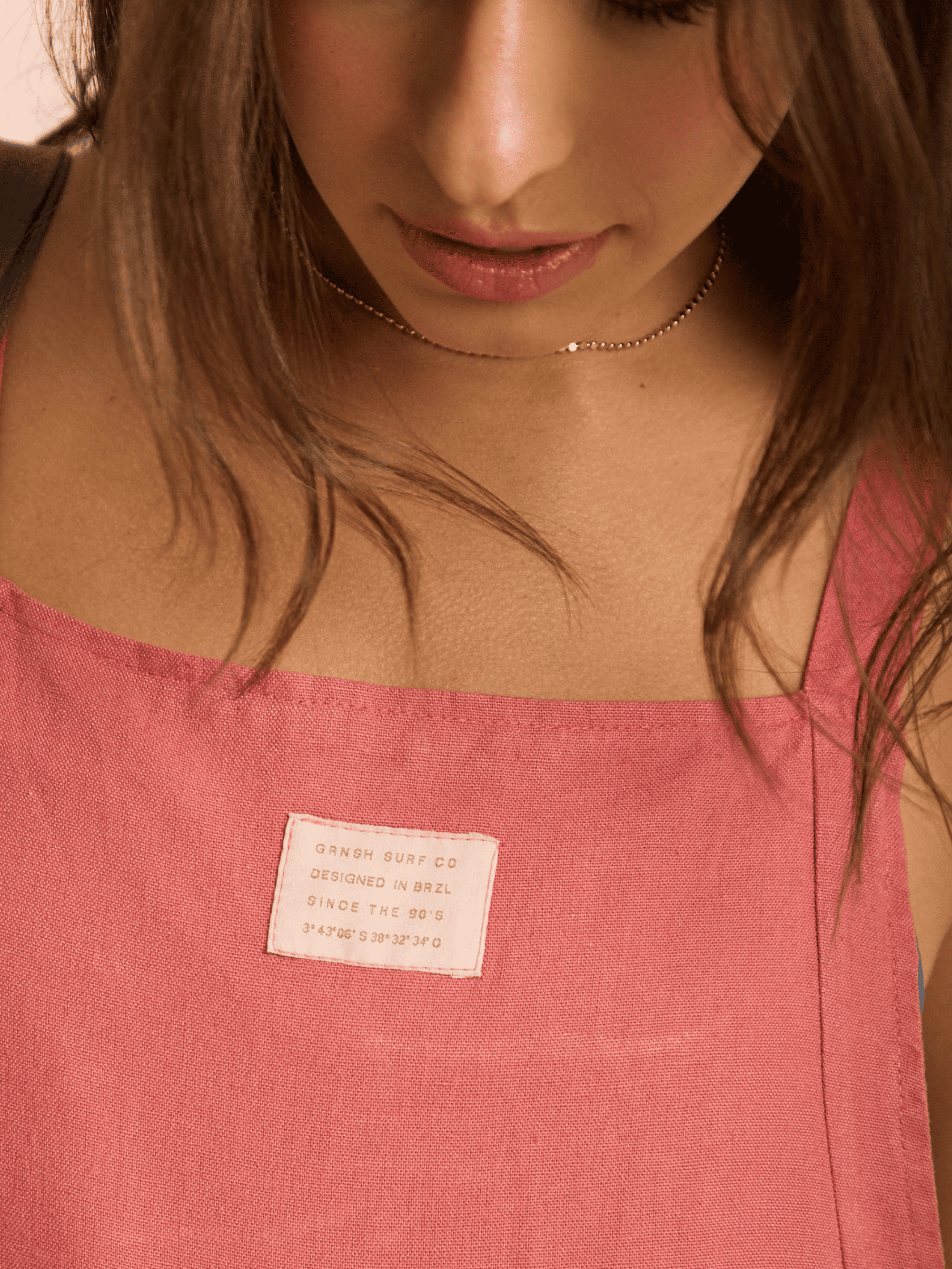 Imagem do macacão telha da Greenish, com detalhe da etiqueta, destacando estilo e conforto.