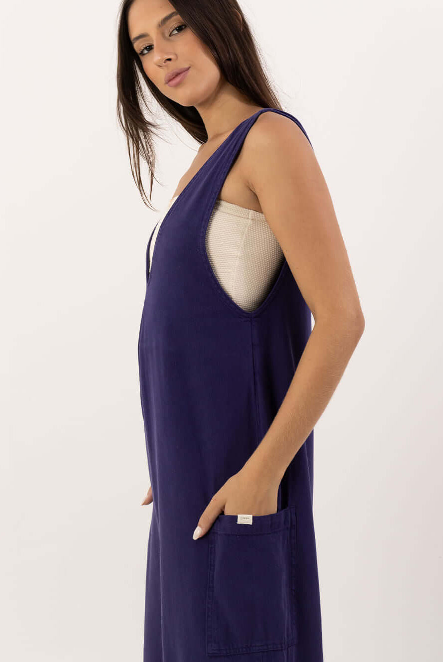 Modelo usando o Macacão Nath azul marinho da marca Greenish, destacando o design moderno e prático.