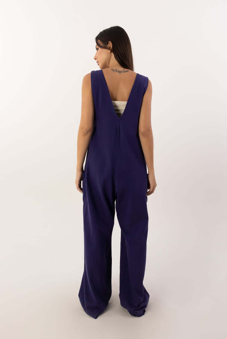 Mulher usando o macacão Nath azul marinho da marca Greenish, vista traseira, estilo moderno e confortável.
