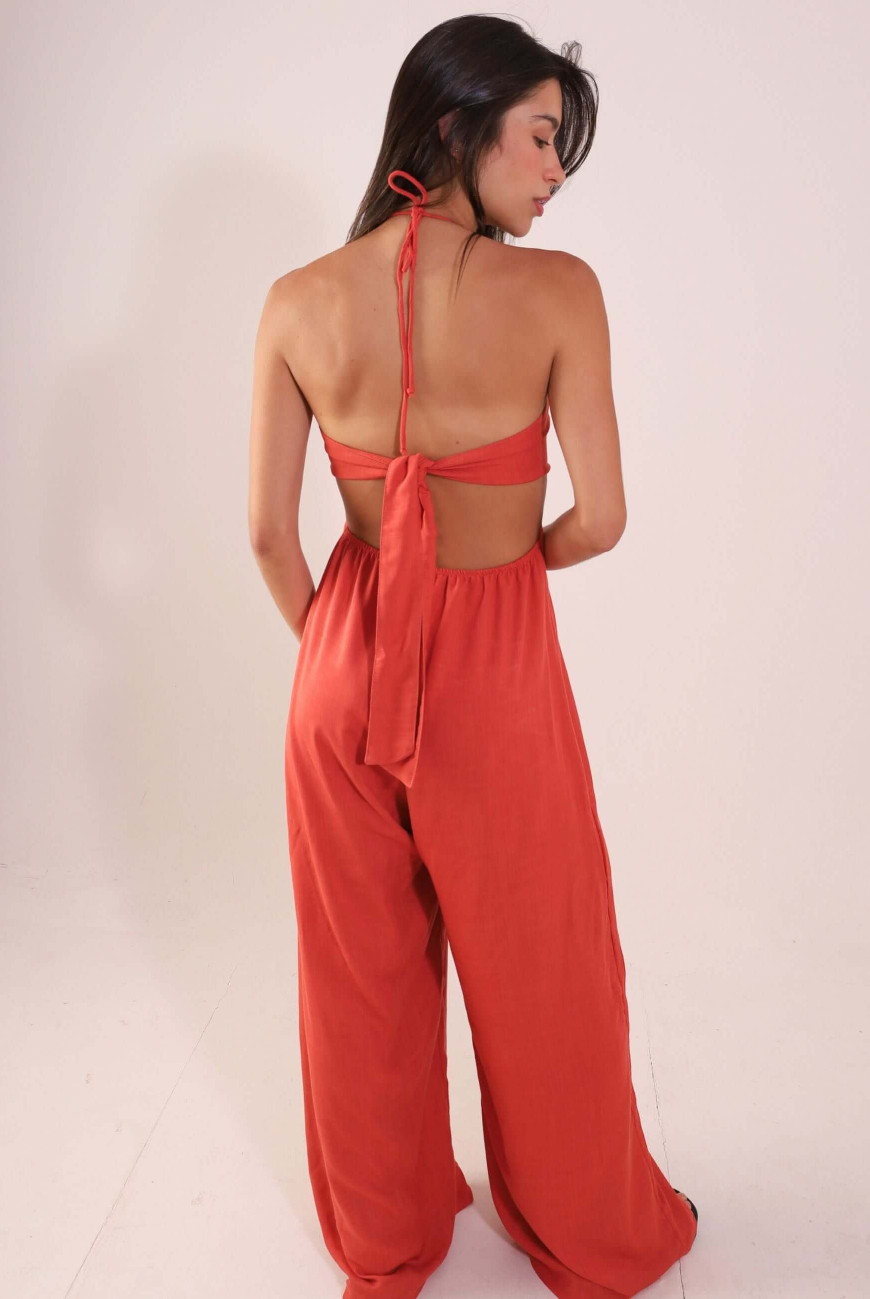 Mulher vestindo Macacão Rustic - Telha, de costas, com alças amarradas e tecido fluido, destacando o ajuste e conforto para dias quentes.