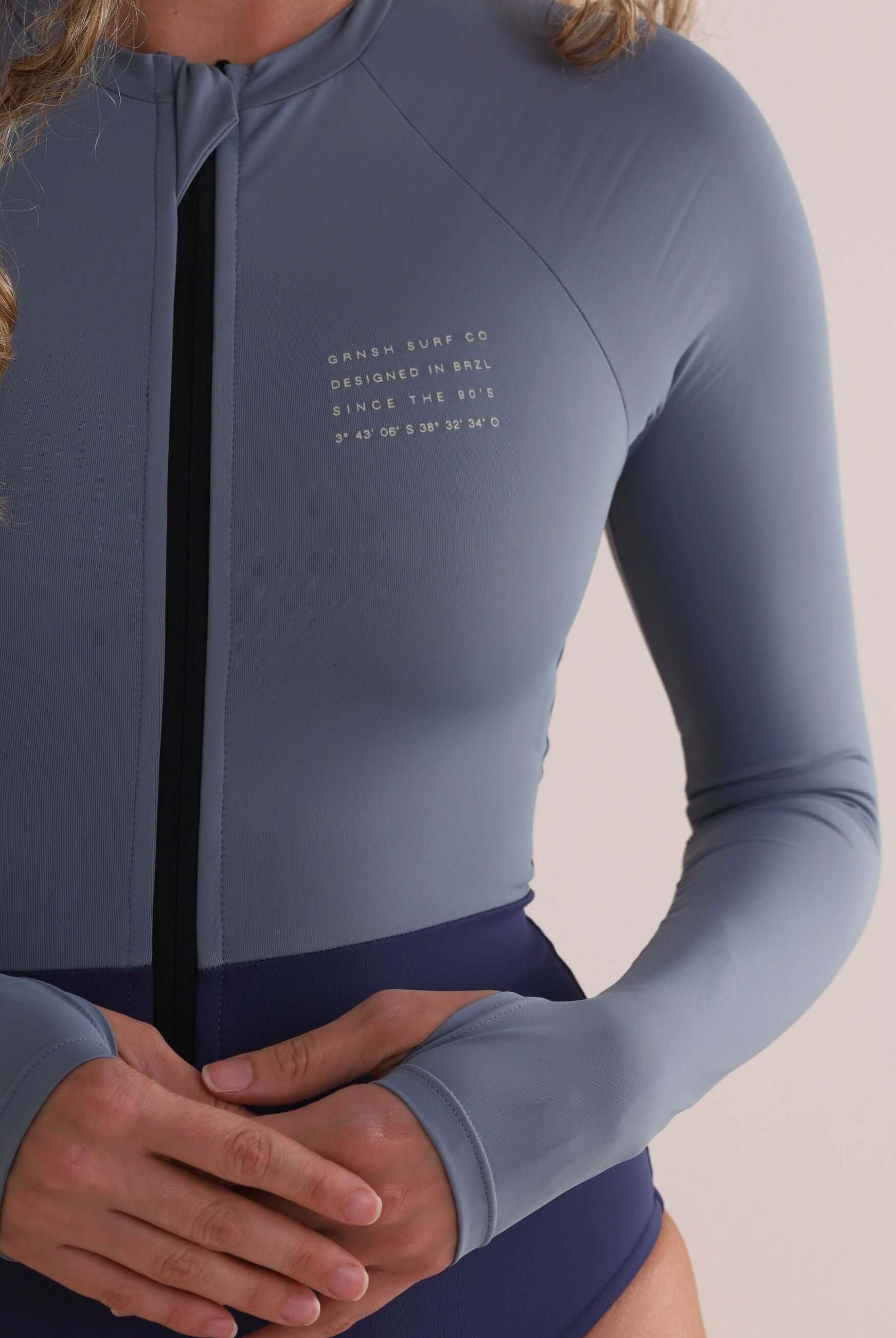 Maiô Manga Longa Joana Duo Color - Azul Greenish, ideal para surf e beach tennis, com abertura para polegar e estilo esportivo.