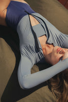 Mulher vestindo Maiô Manga Longa Joana Duo Color - Azul da Greenish, ideal para esportes aquáticos e proteção solar elegante.