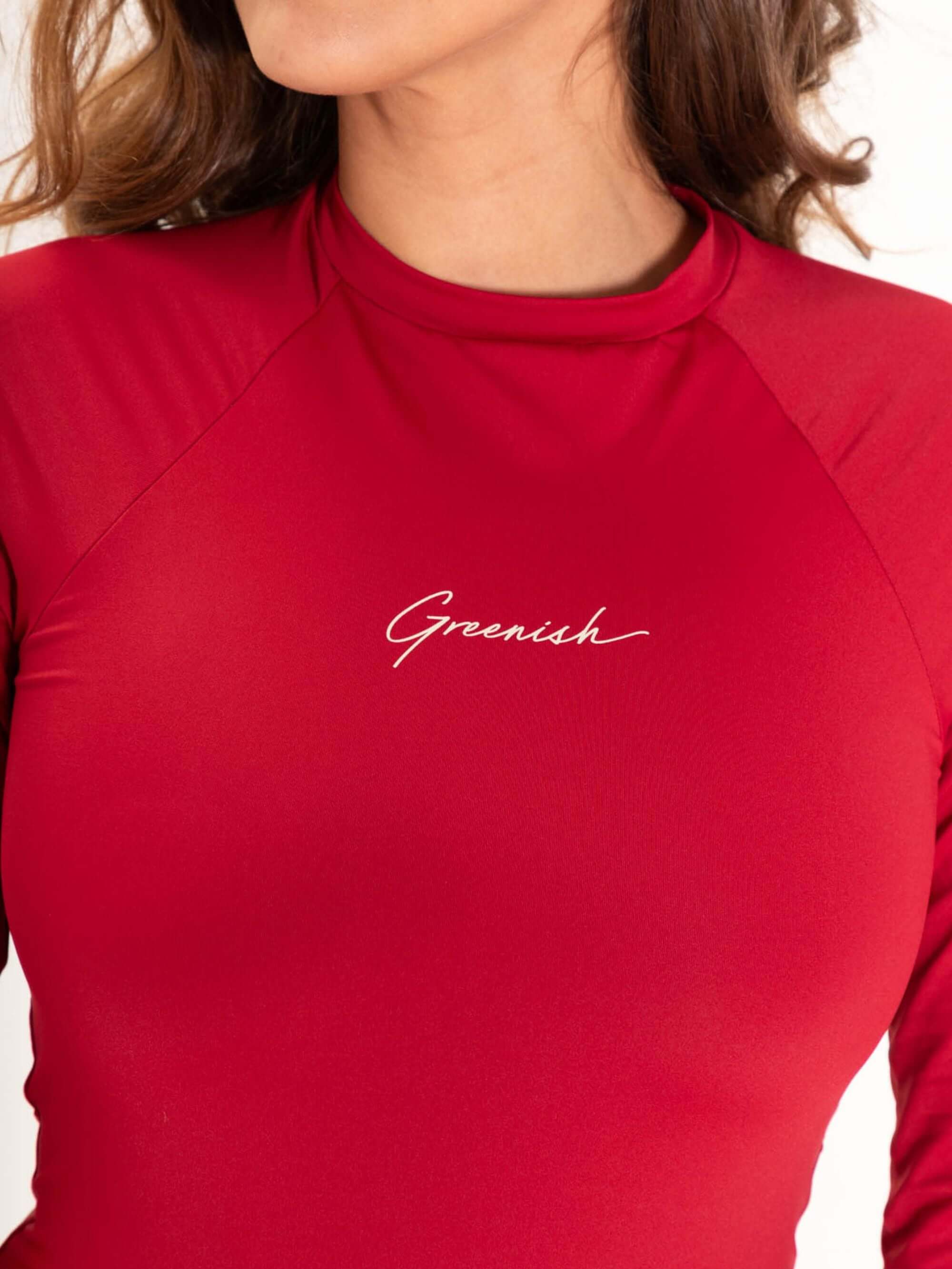 Modelo usando maiô verde Bayshore vermelho com logotipo 'Greenish' destacado no peito.