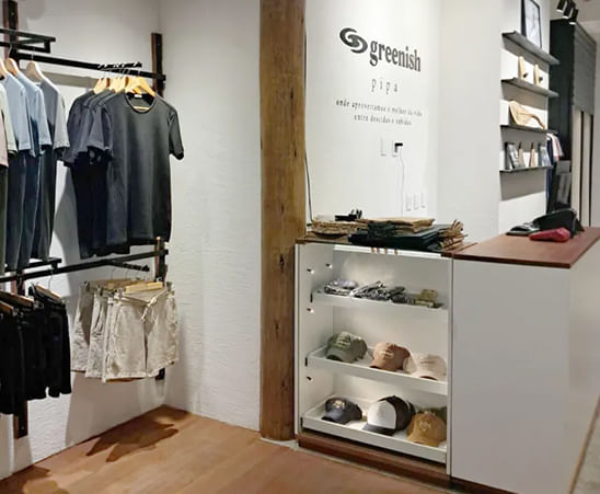 Loja Greenish com camisetas e acessórios em exposição, mostrando moda sustentável e estilo moderno.