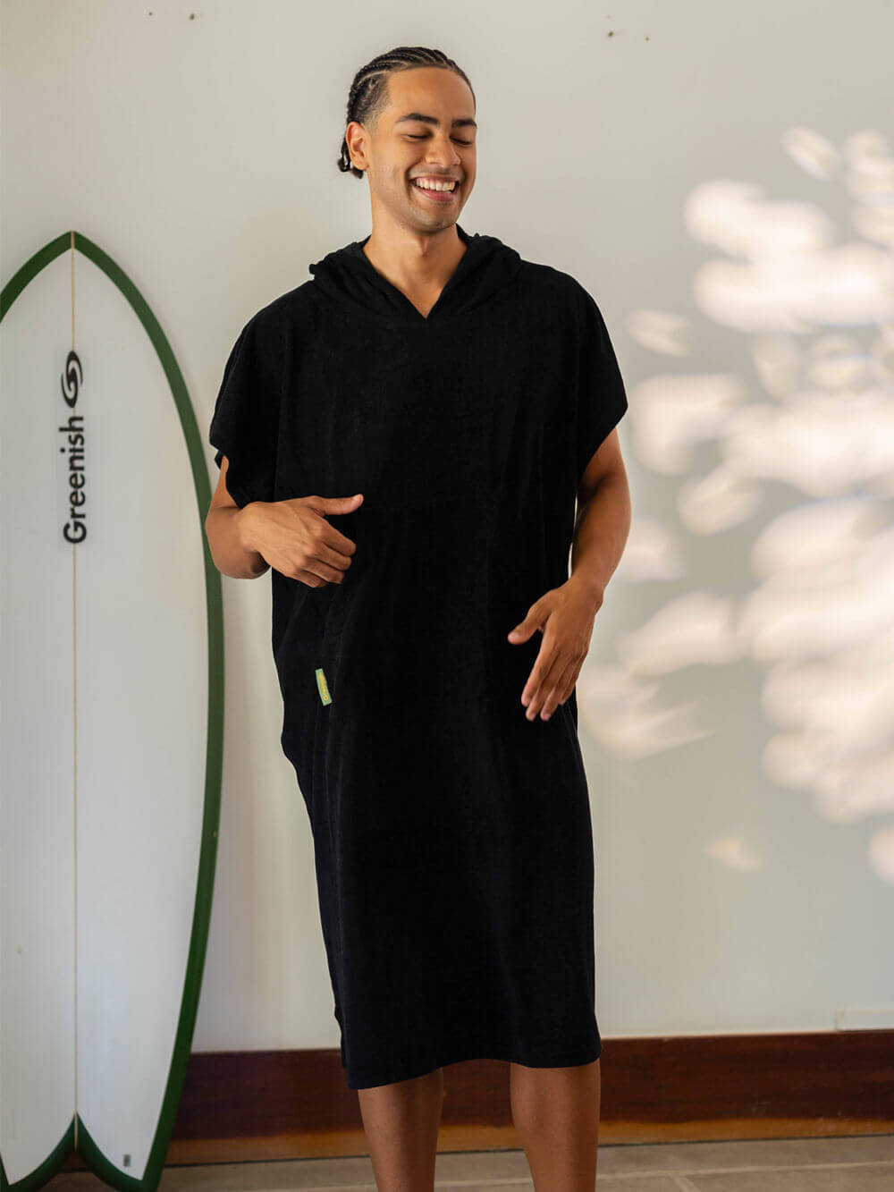 Homem sorridente usando poncho adulto Black da Greenish, ideal para praia e esportes aquáticos.