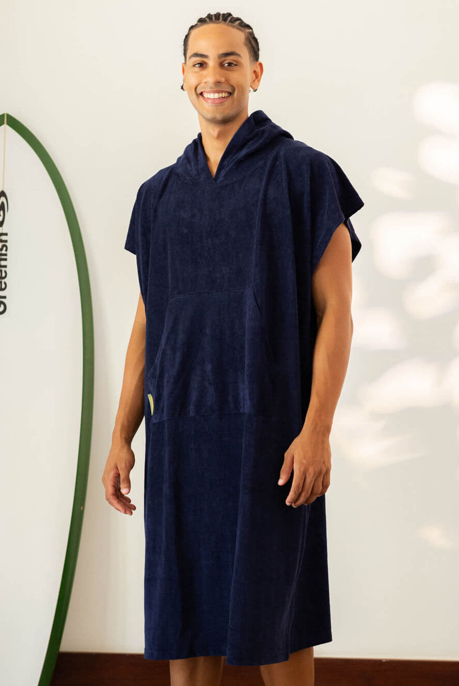Modelo usando o Poncho Adulto Bolso Canguru Azul Marinho da Greenish, ideal para a praia e esportes aquáticos.