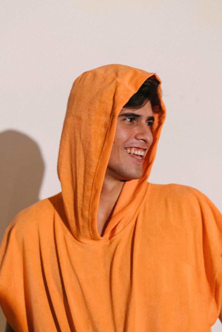 Poncho adulto canguru Greenish na cor coral, ideal para praia e esportes aquáticos, oferecendo conforto e privacidade.