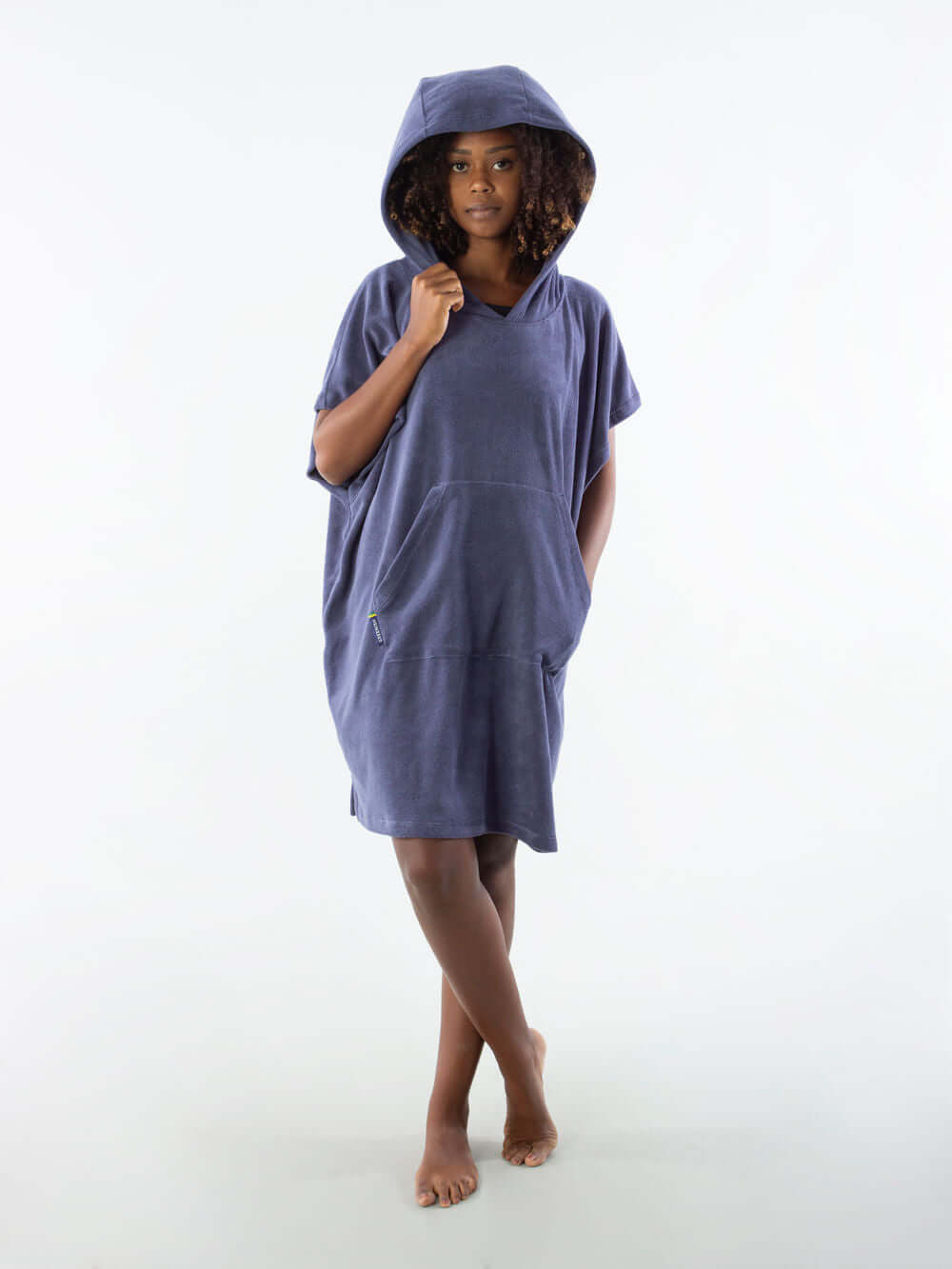 Modelo vestindo poncho curto atoalhado azul marinho com capuz e bolso canguru.