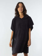 Poncho curto atoalhado preto com capuz e bolso frontal, ideal para praia e esportes aquáticos.