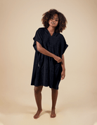 Moda praia: Poncho curto atoalhado preto com bolso, ideal para aquecer e oferecer privacidade em práticas aquáticas.