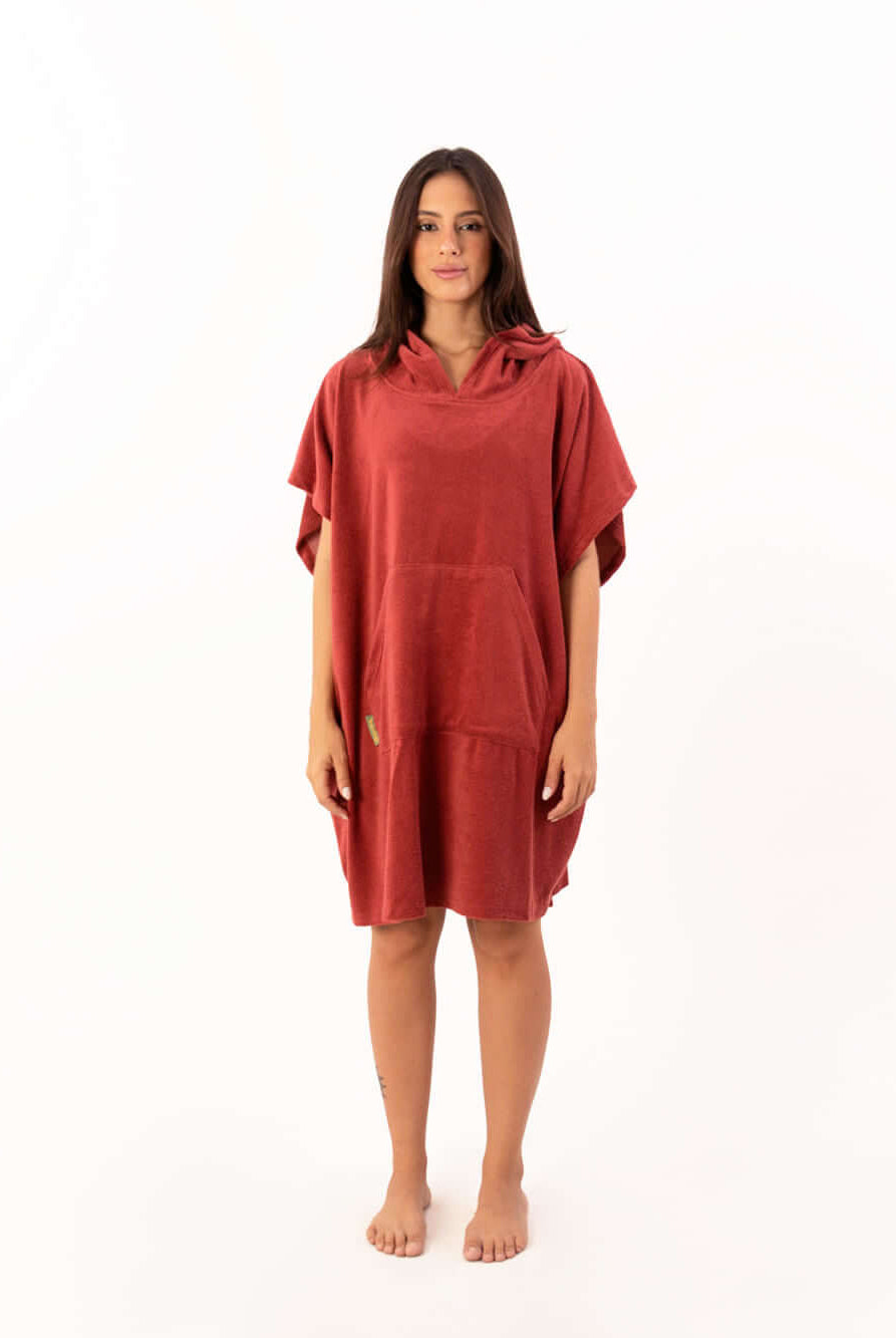 Modelo usando poncho curto atoalhado telha com bolso canguru, perfeito para praia e esportes aquáticos.