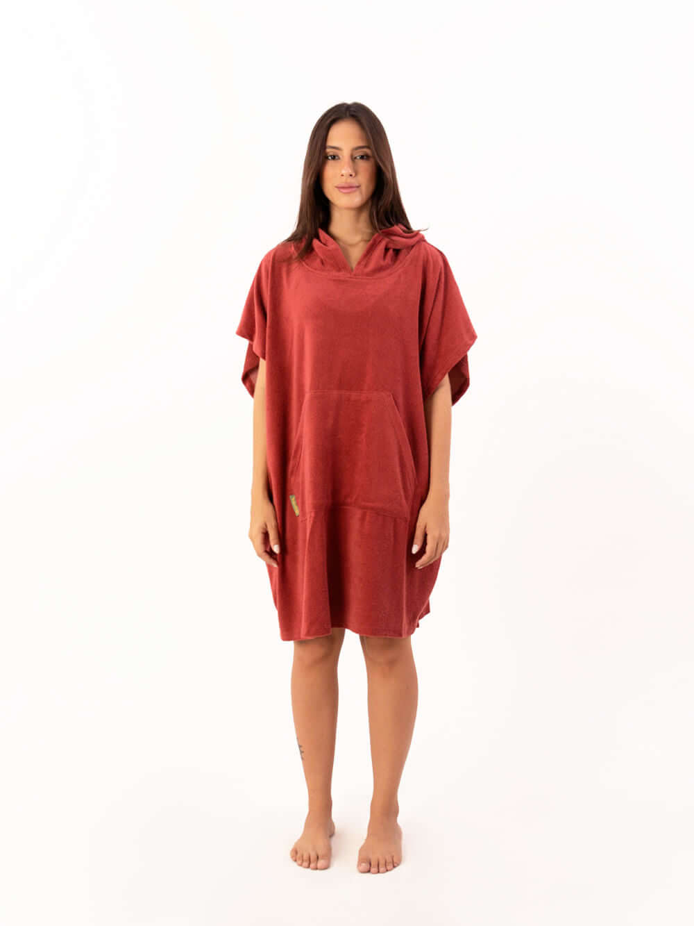 Modelo usando poncho curto atoalhado telha com bolso canguru, perfeito para praia e esportes aquáticos.