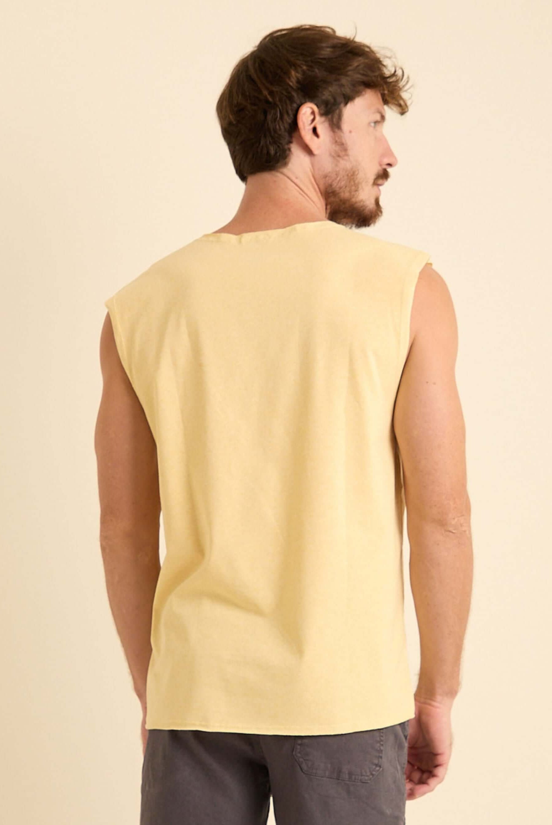 Homem usando Regata Larga New Logo Amarelo da Greenish, mostrando a parte traseira e modelagem ampla.