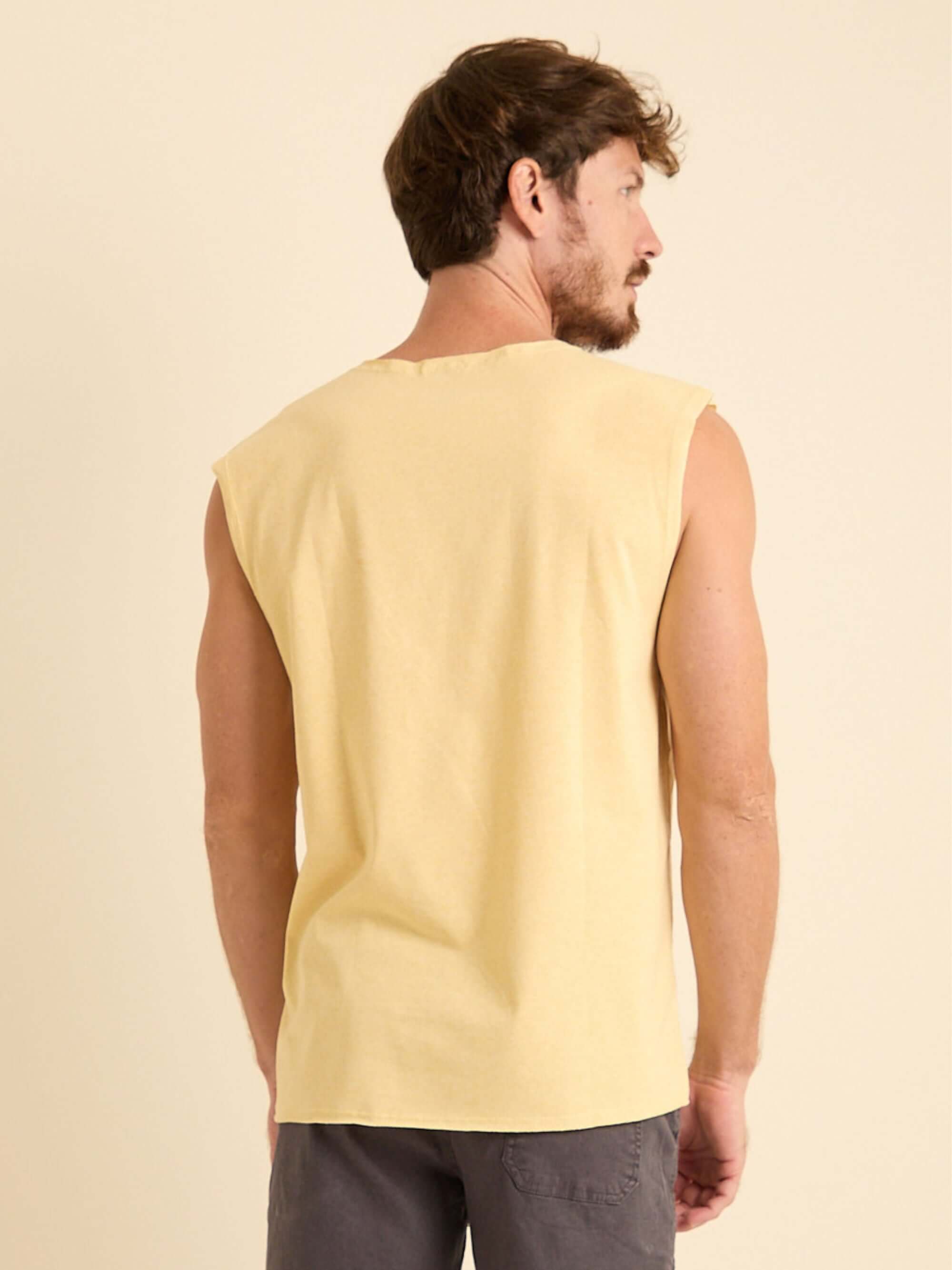 Homem usando Regata Larga New Logo Amarelo da Greenish, mostrando a parte traseira e modelagem ampla.