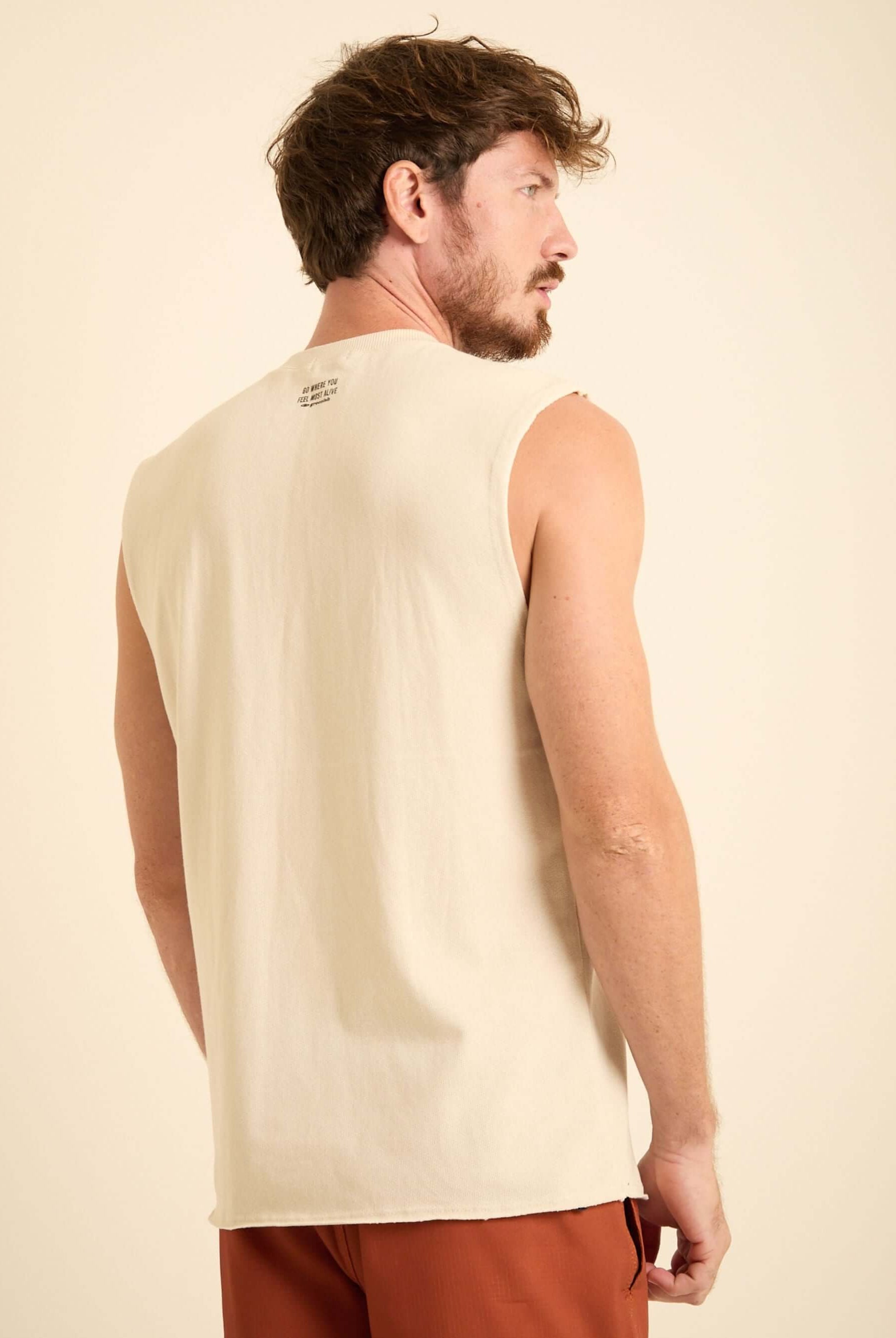 Homem usando regata larga bege da Greenish, vista de costas, ideal para atividades do dia a dia.