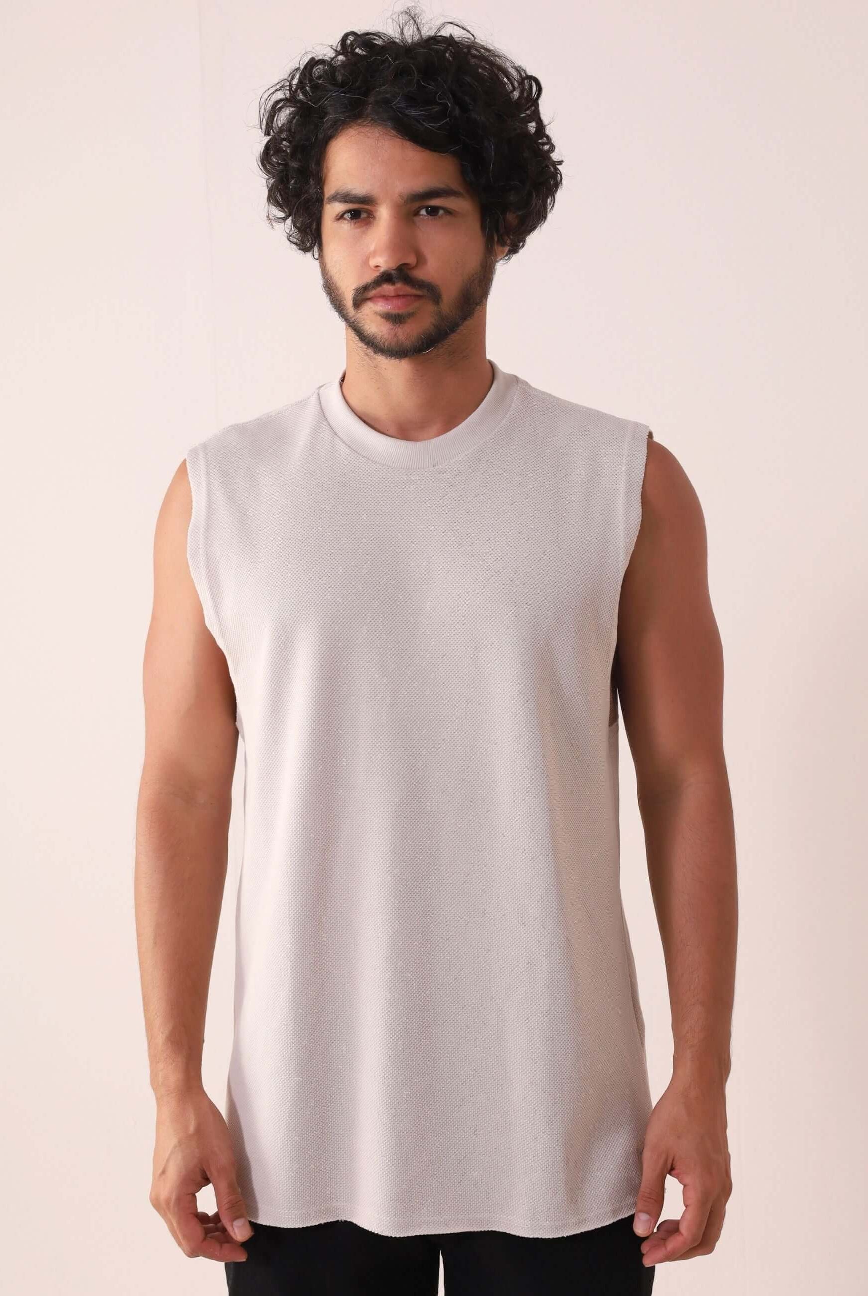 Homem vestindo Regata Larga Waves - Natural da Greenish, modelo confortável dos anos 90 com acabamento a fio e detalhe bordado elegante.