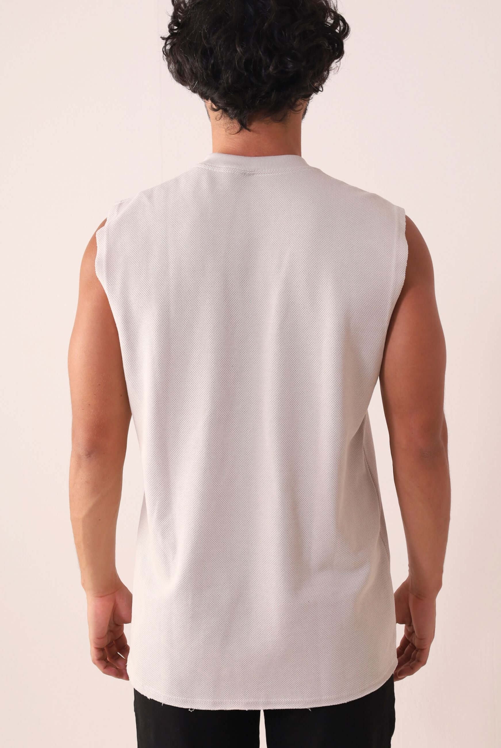 Homem vestindo REGATA LARGA WAVES - NATURAL da Greenish, modelagem larga, gola ribana, ideal para movimento. Estilo anos 90.