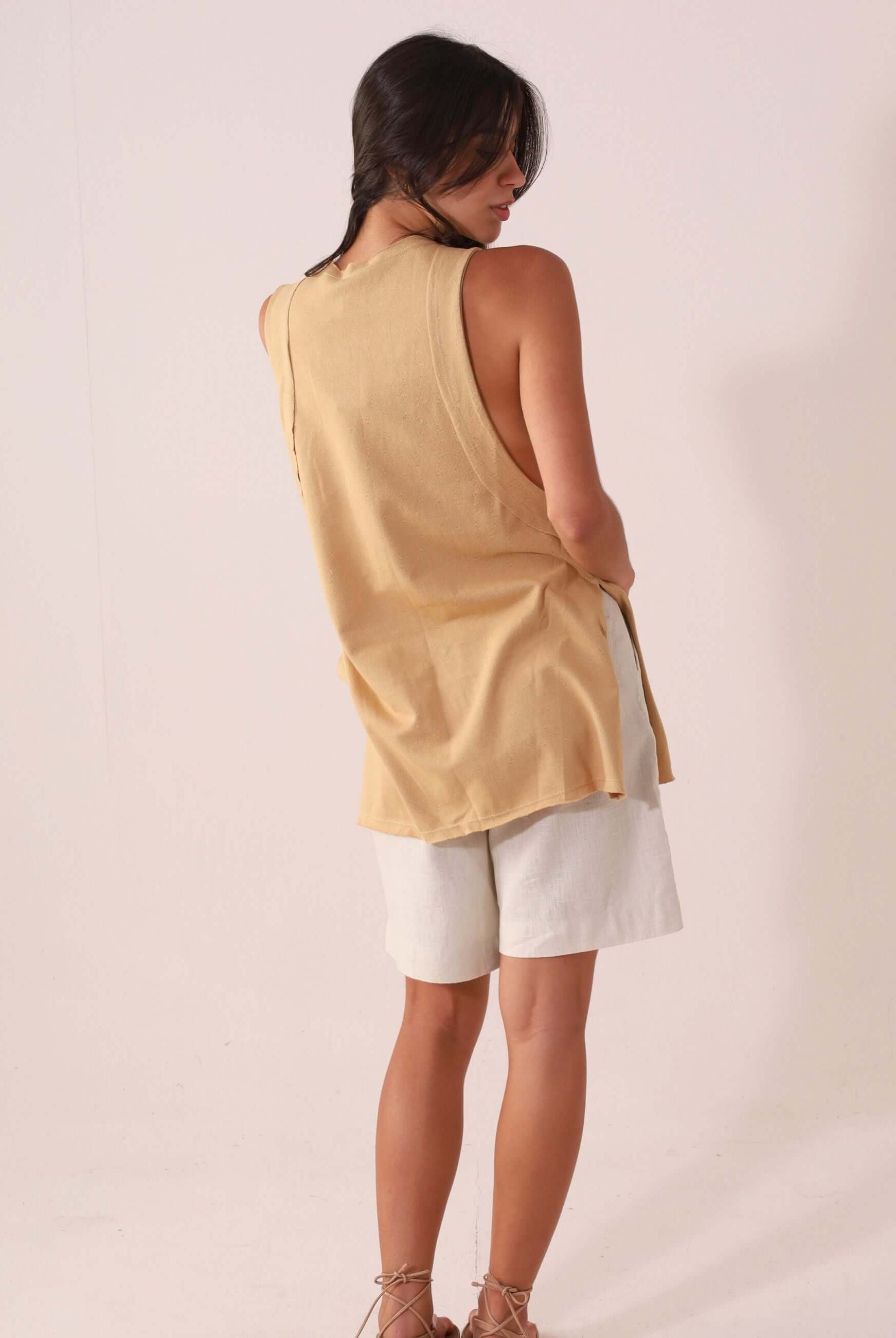 Mulher vestindo a Regata Déa - Caqui da Greenish, peça leve e confortável, ideal para looks casuais e pós-surf.