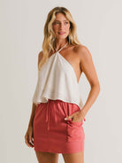 Saia Curta Beth Telha da marca Greenish, com cós elástico, bolsos laterais e caimento ajustado.