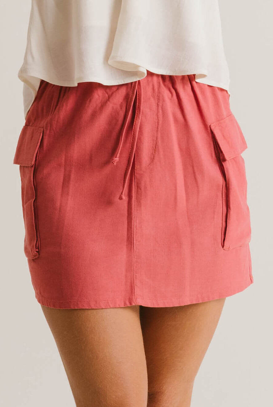 Saia Curta Beth da Greenish na cor telha, com cós elástico e bolsos laterais. Estilo moderno e prático.