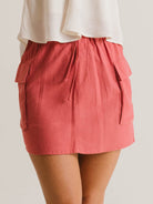 Saia Curta Beth da Greenish na cor telha, com cós elástico e bolsos laterais. Estilo moderno e prático.